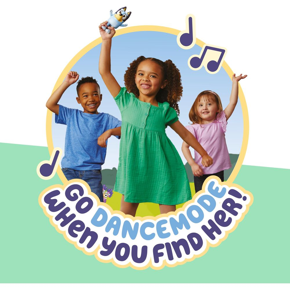 Tre bambini ballano felici. Una bambina tiene un giocattolo di Bluey sopra la testa.