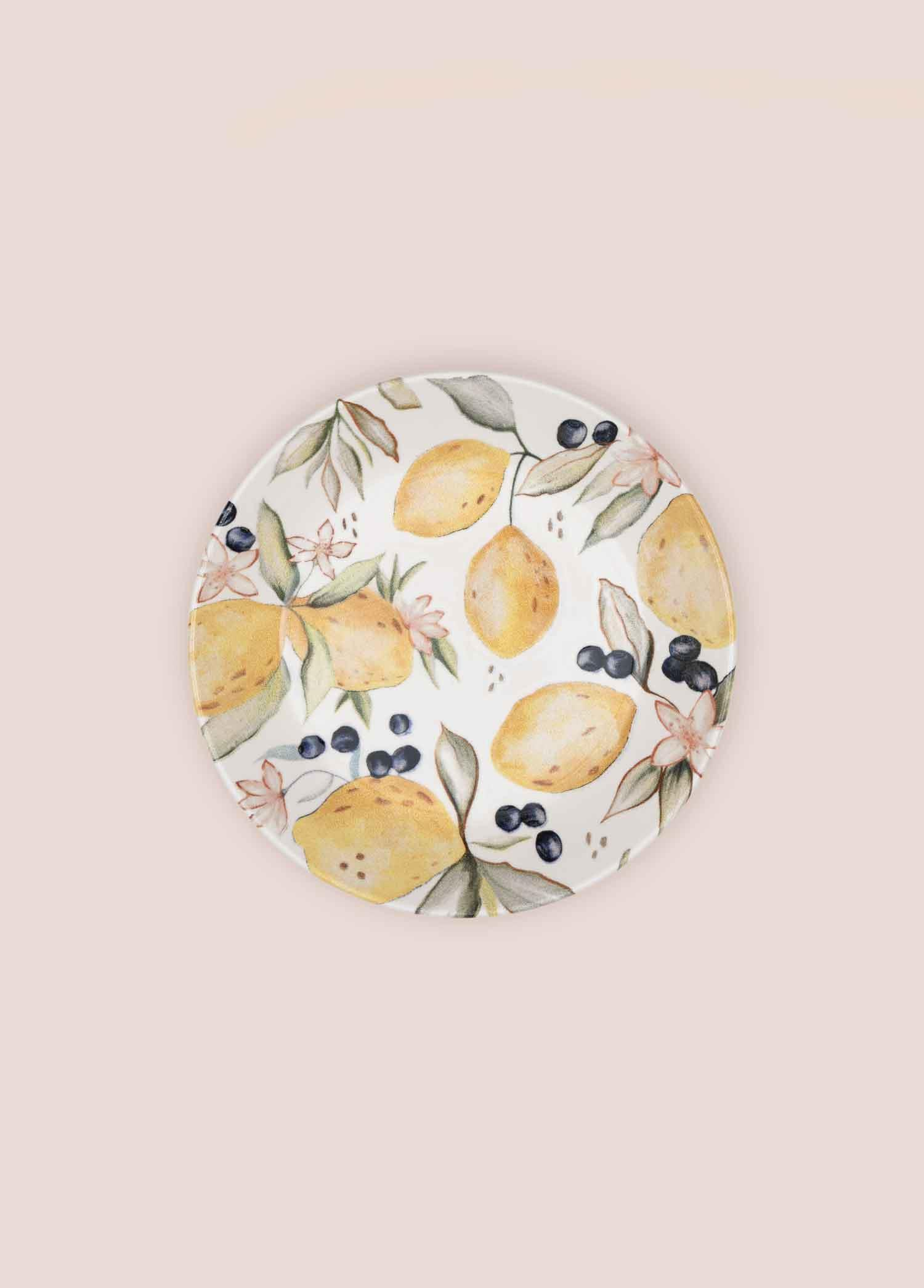 Açık renkli zeminde limon ve yaban mersini desenli tabak.