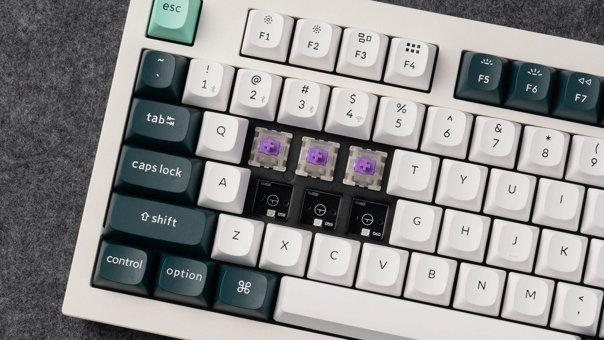 Tastiera bianca con tasti scuri e switch viola. Vista ravvicinata.