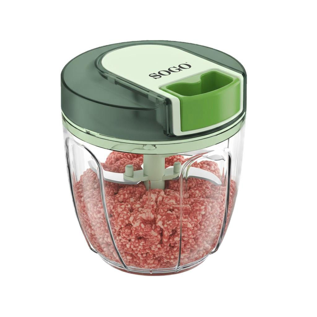 Un tritatutto manuale verde con lame, riempito di carne macinata.