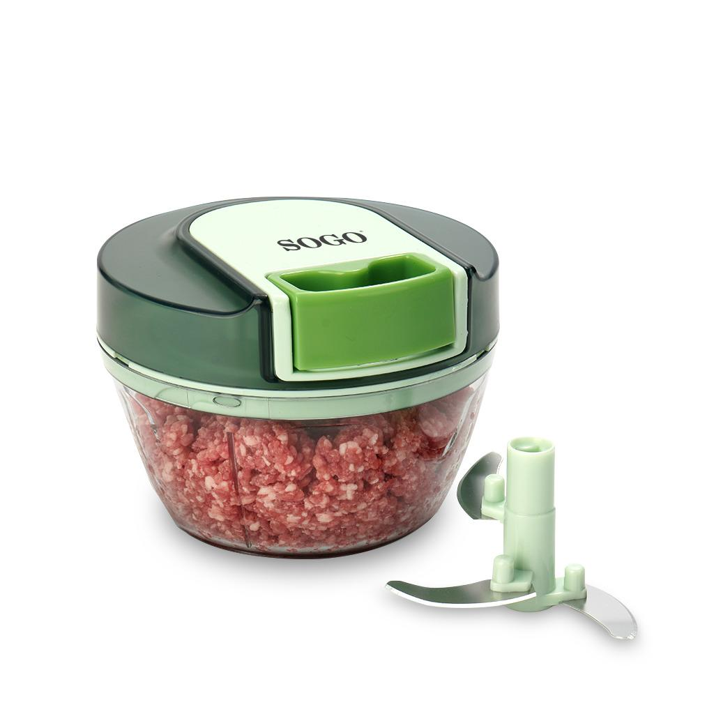 Un tritatutto manuale verde con carne macinata nel contenitore.
