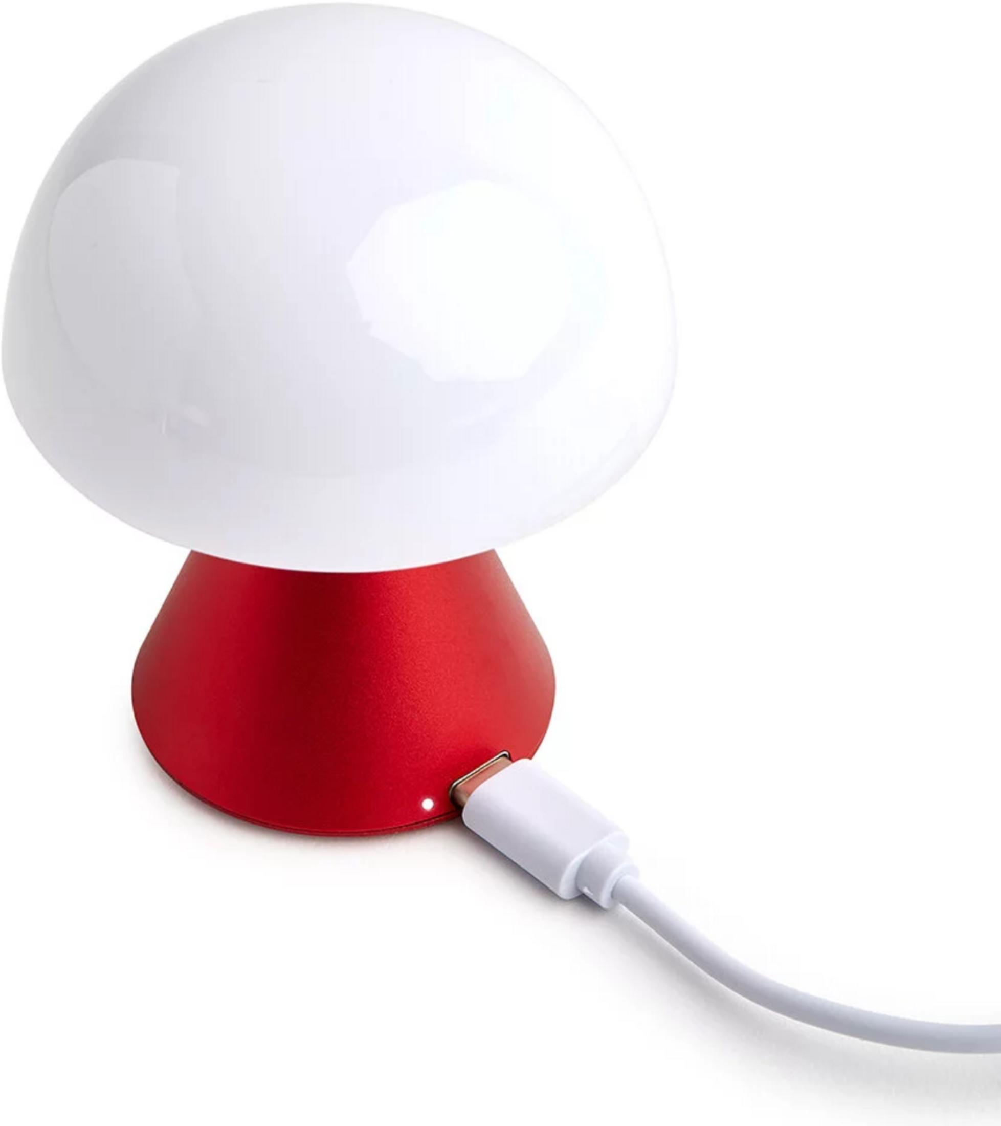 Eine weiße Pilzlampe mit rotem Sockel, die mit einem weißen Kabel aufgeladen wird.