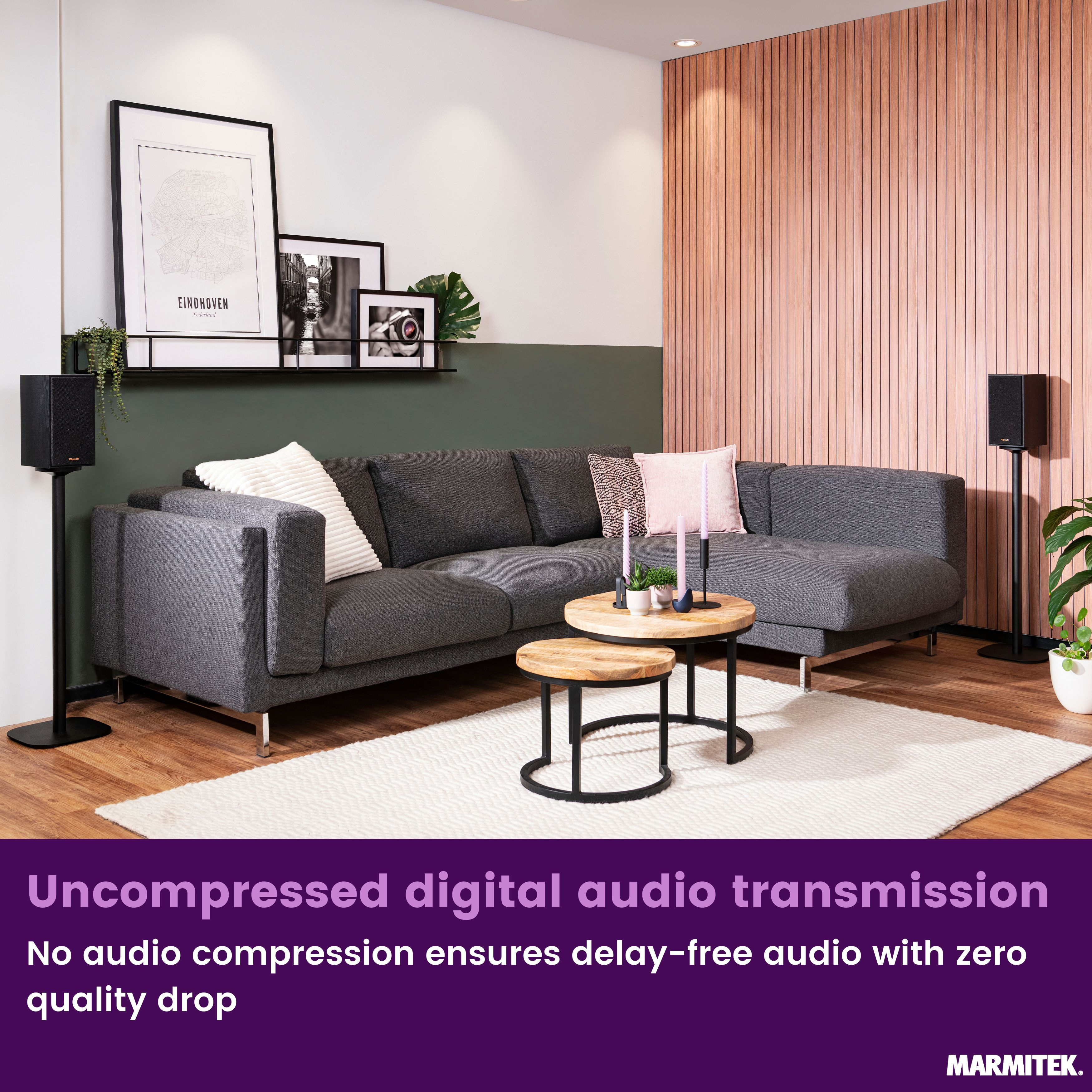 A living room with a sofa, coffee tables, speakers, and artwork.
