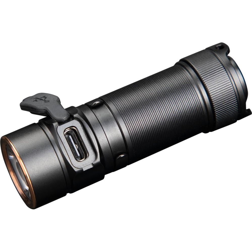 Une lampe torche tactique noire avec port USB et anneau en cuivre autour de la lentille.