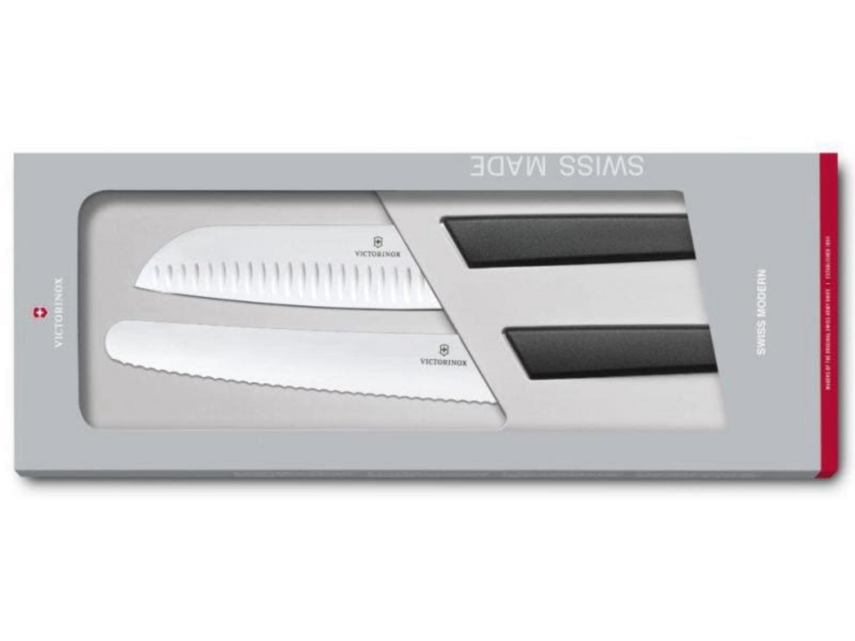 Zwei weiße Victorinox-Messer mit schwarzen Griffen in einer grauen Geschenkbox.