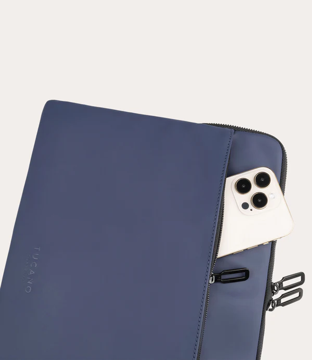 Eine dunkelblaue Laptoptasche mit einem Smartphone, das teilweise in einer Außentasche steckt.