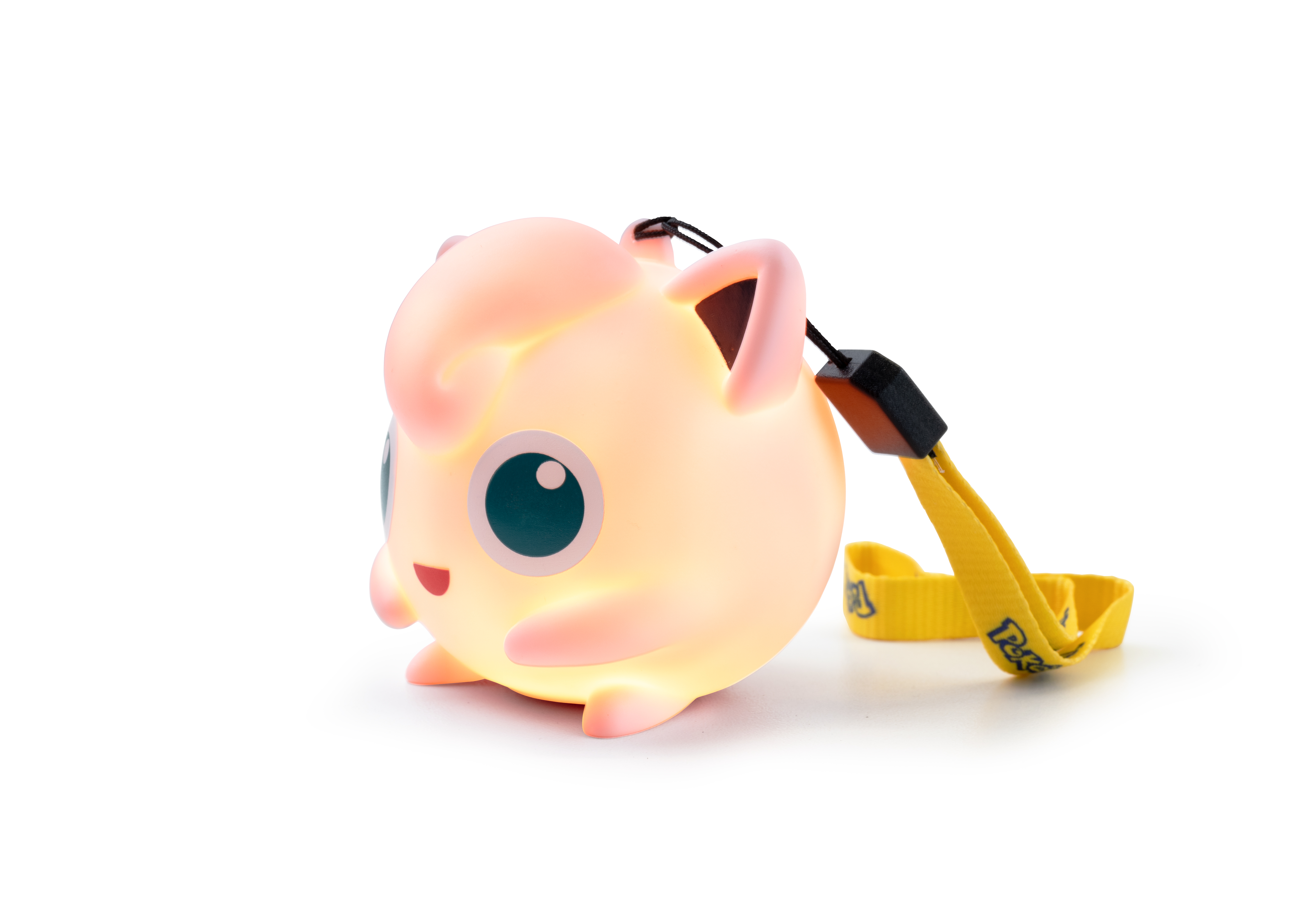 Una figura brillante de Jigglypuff rosa con cordón amarillo sobre fondo blanco.