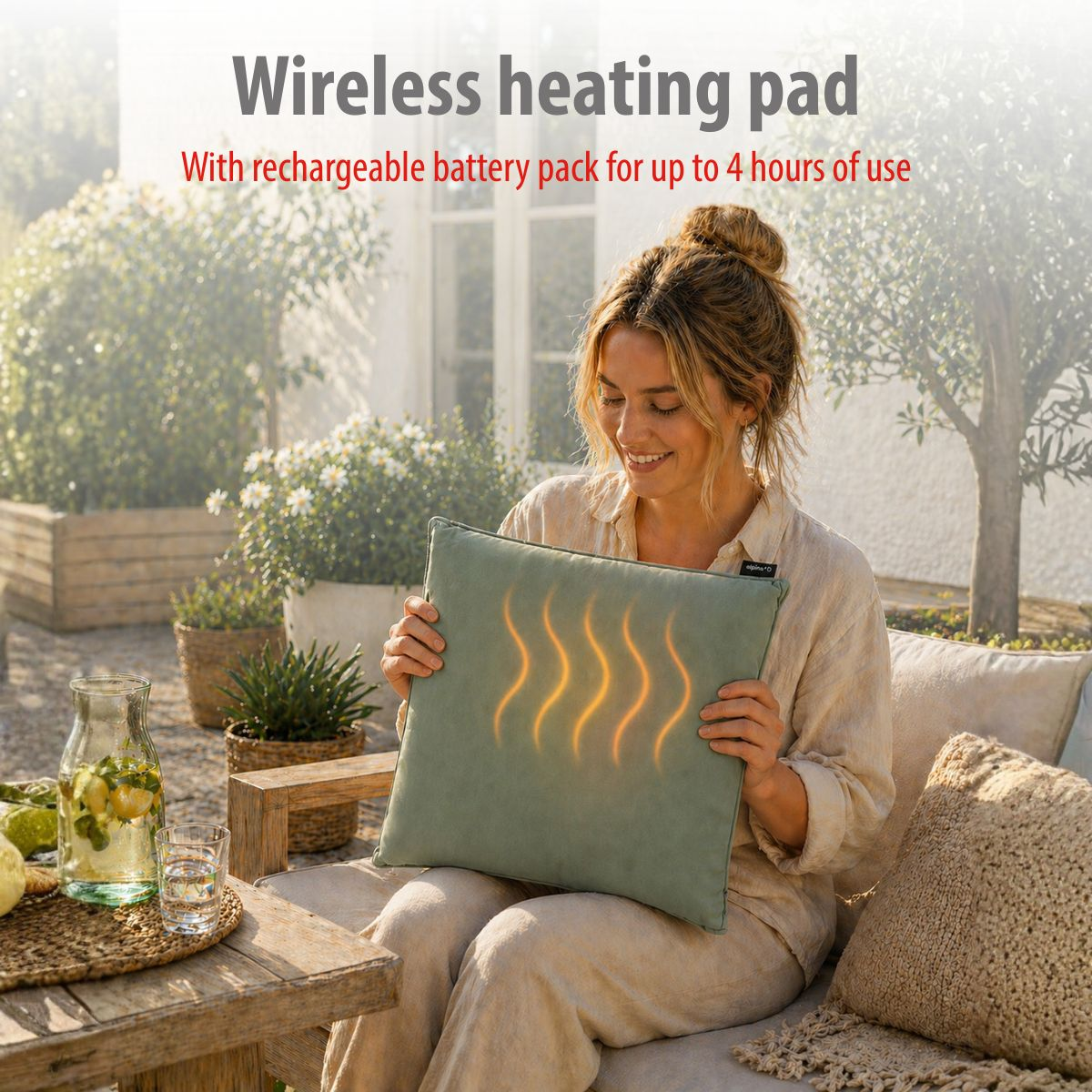 Woman holds a green heating pad with glowing waves. She is sitting outdoors.