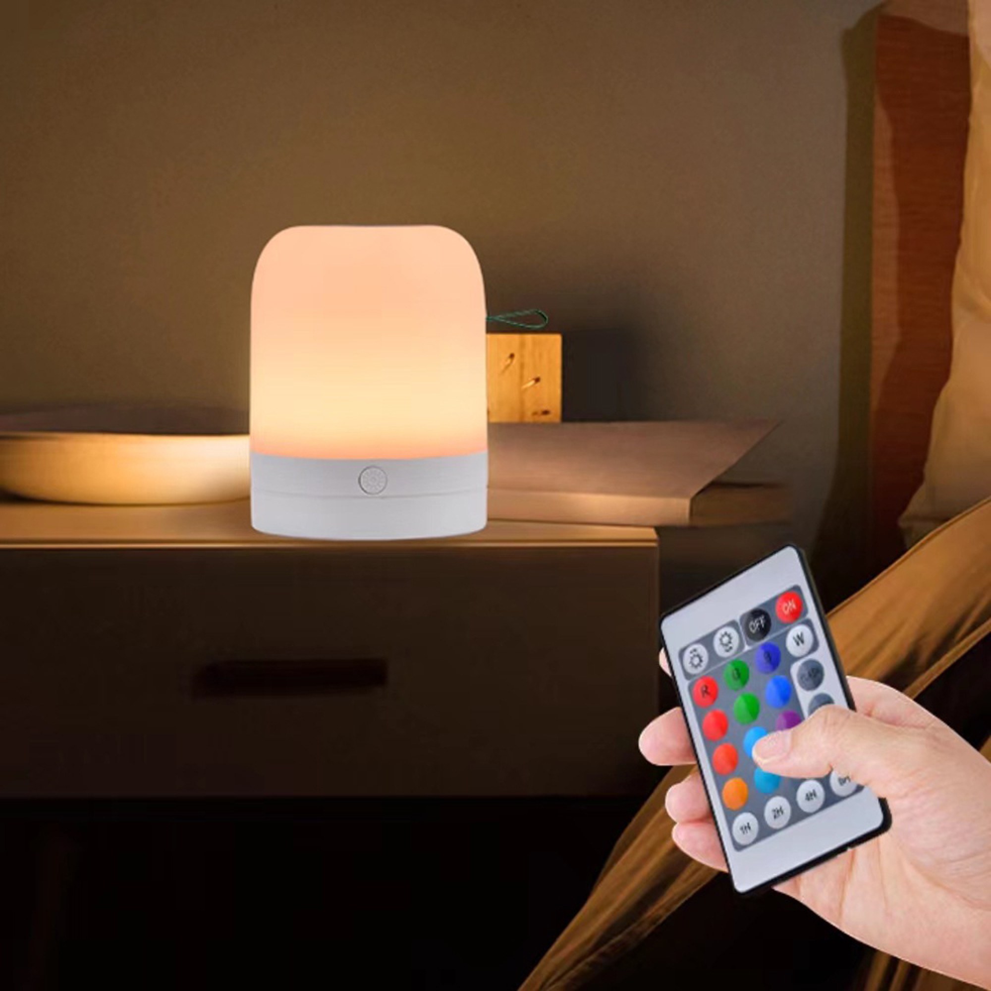 Ein weißer Nachttisch mit einer runden Lampe und einer Fernbedienung.