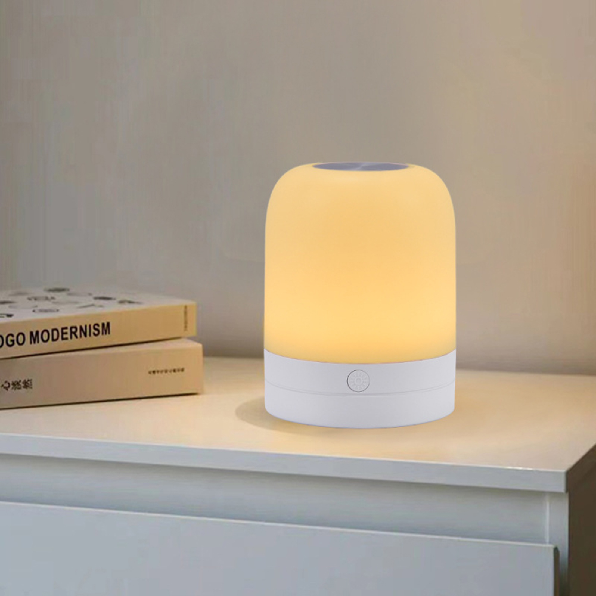 Eine leuchtende Nachttischlampe auf einem Tisch neben Büchern.
