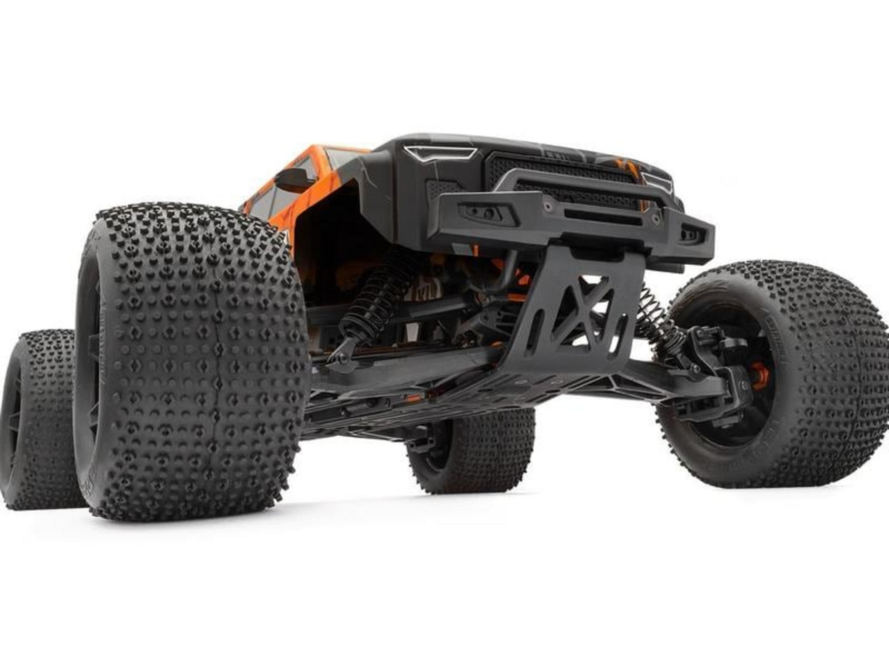 Un camión monstruo RC naranja y negro con neumáticos grandes y rugosos.