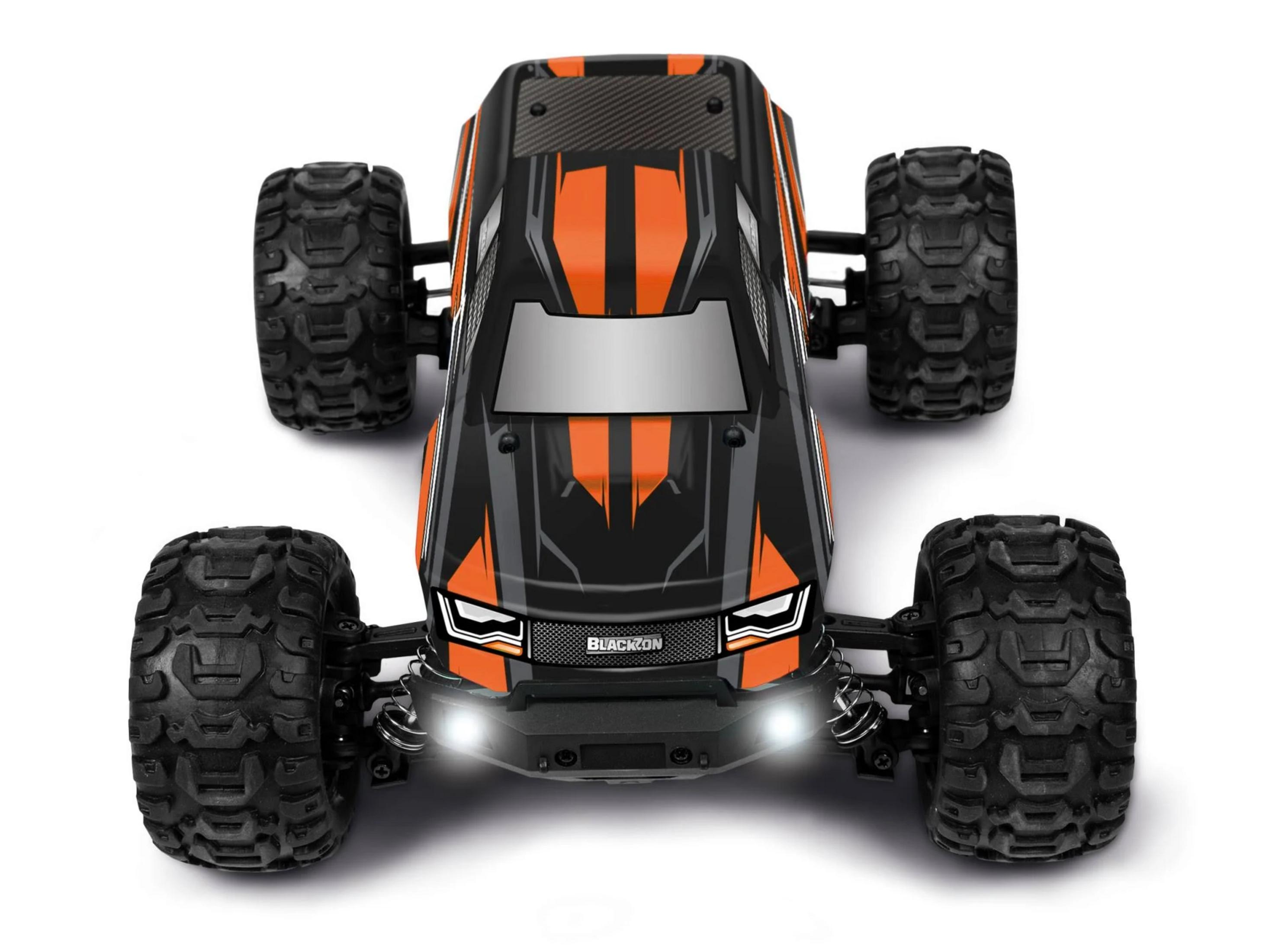 Voiture RC noire à rayures oranges et gros pneus, vue de face.
