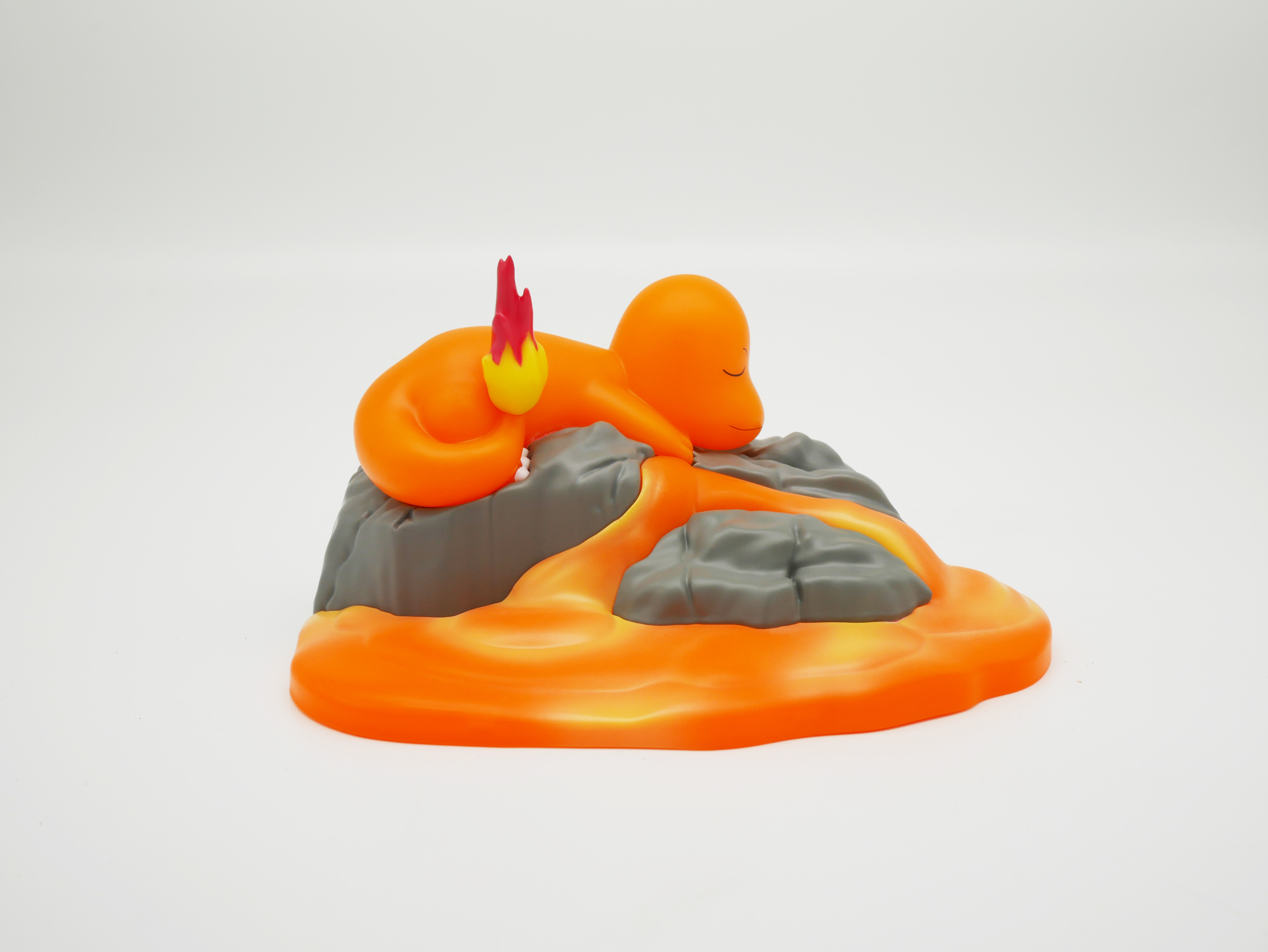 Orangefigur mit Flamme auf dem Schwanz schläft auf Felsen über Lava.
