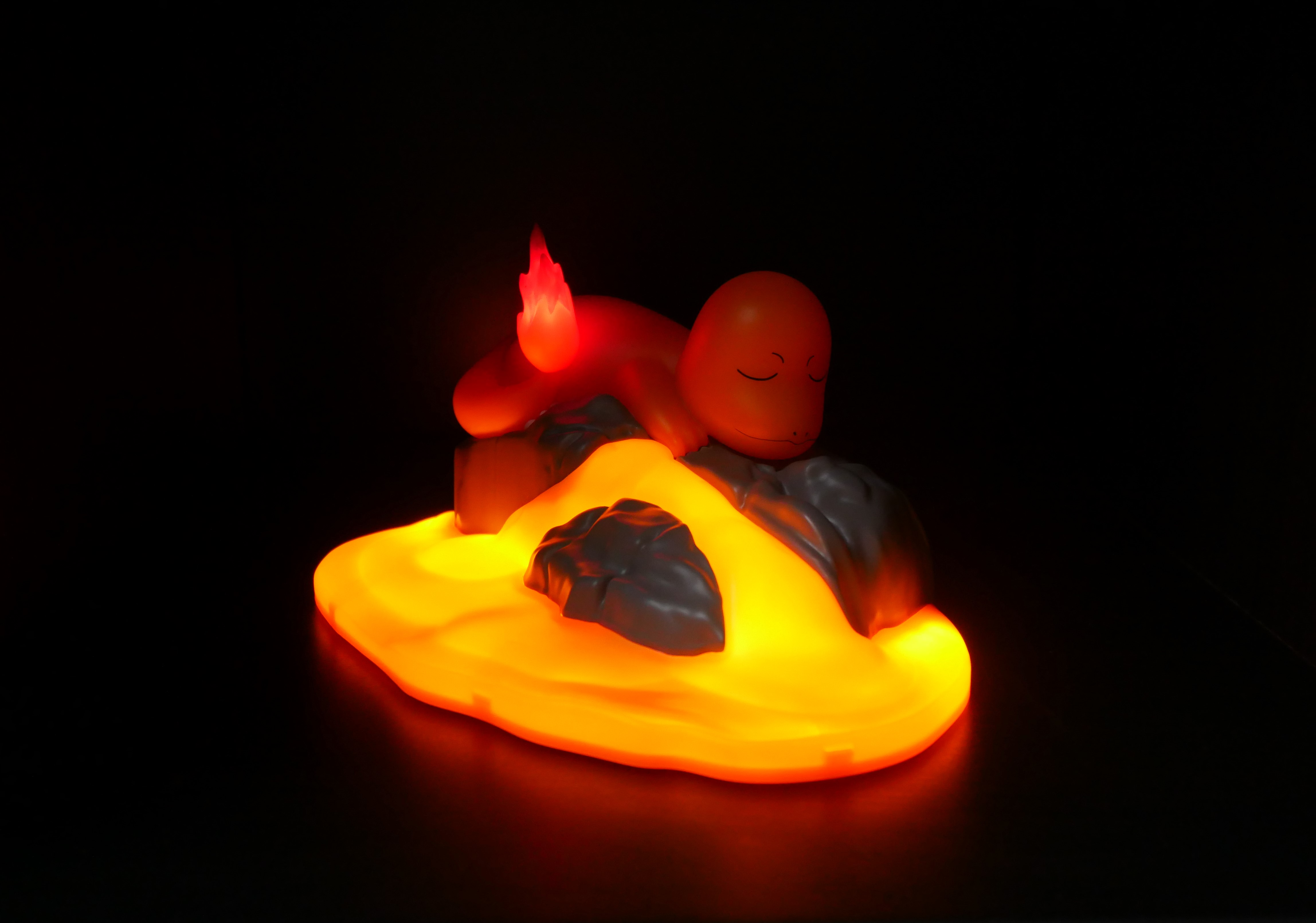 Ein leuchtender Pokémon-Charakter liegt auf Felsen in glühender Lava.