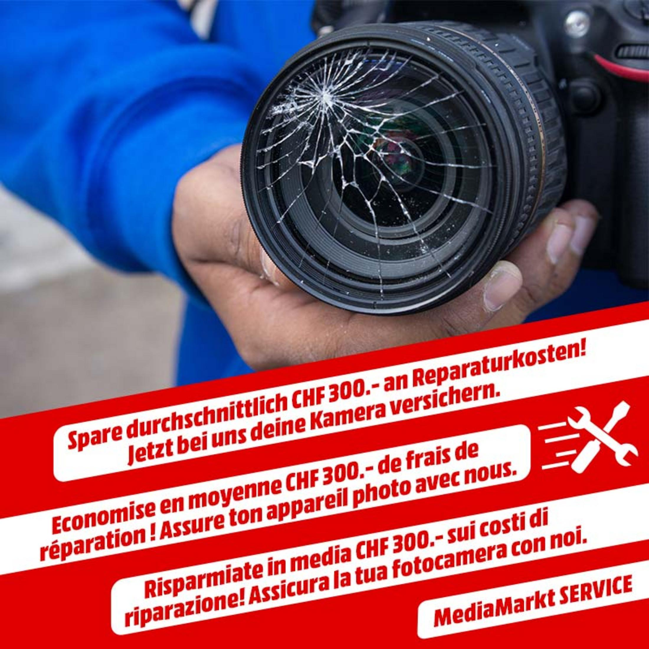 Eine Hand hält eine Kamera mit gesprungenem Objektiv. Werbeanzeige.