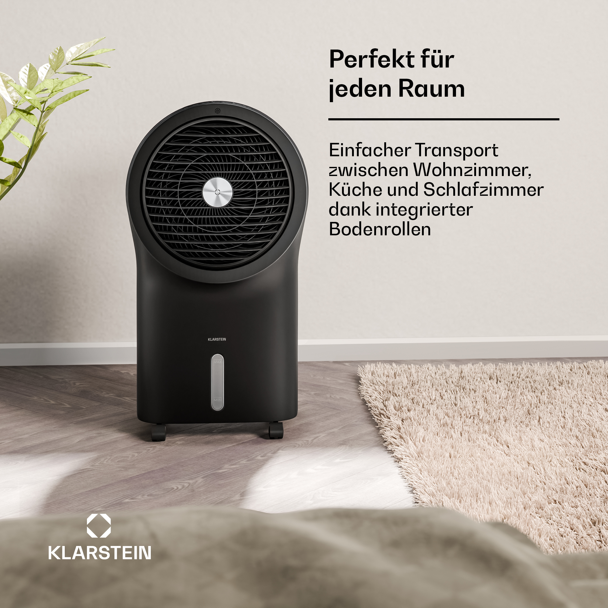 Schwarzer Klarstein Luftkühler mit Rollen neben einer Pflanze und Teppich.