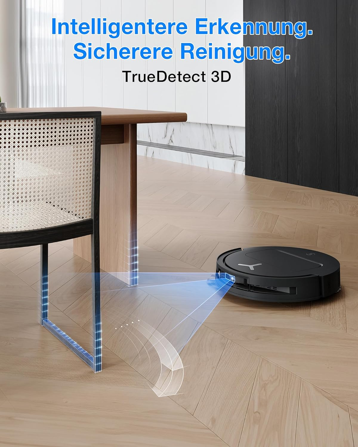 Ein schwarzer Saugroboter reinigt einen Holzboden in der Nähe eines Stuhls und eines Tisches.