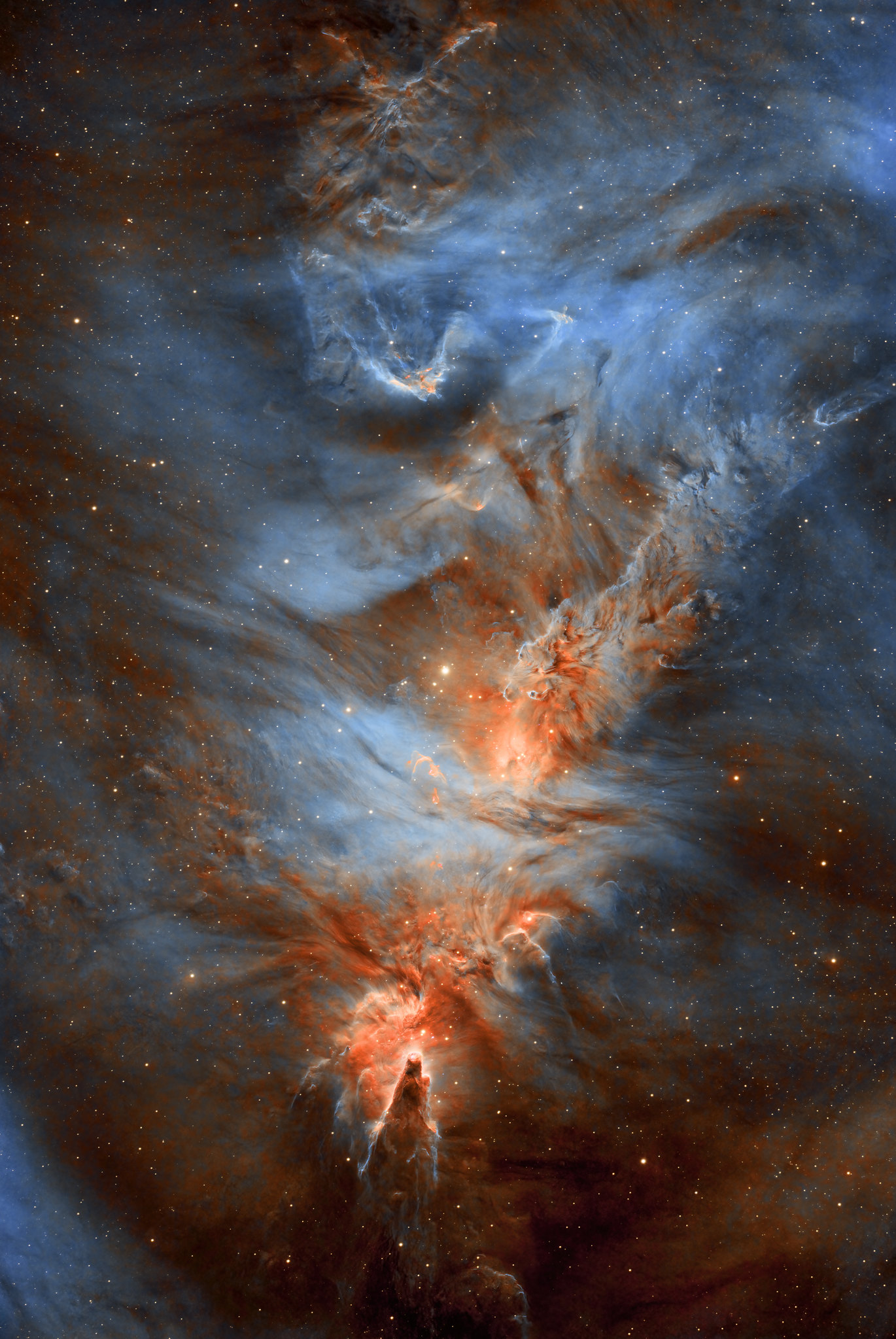 Una nube cósmica de gas y polvo en tonos naranjas y azules con estrellas.