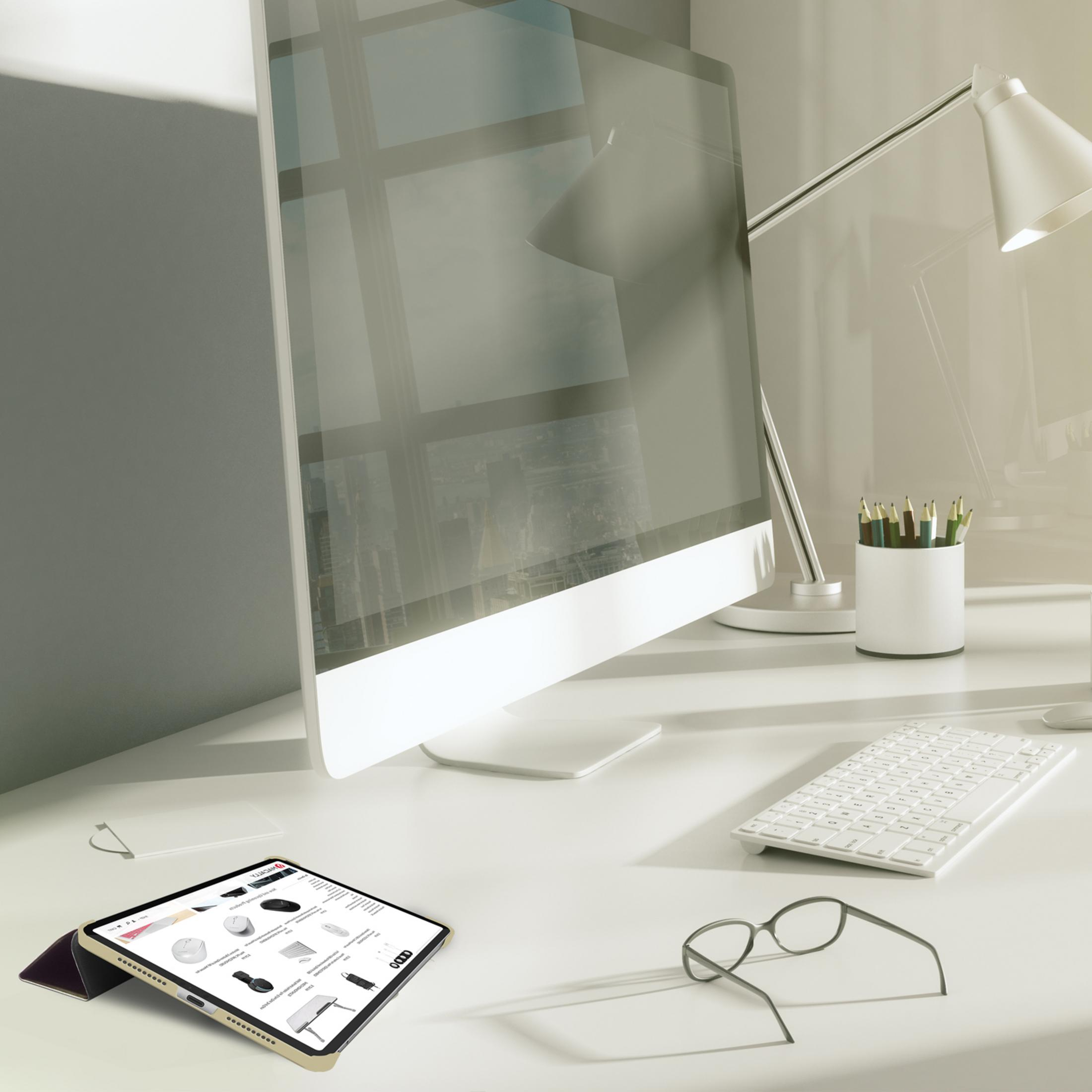 Ein Schreibtisch mit Computer, Tastatur, Brille, Tablet und Stiften.