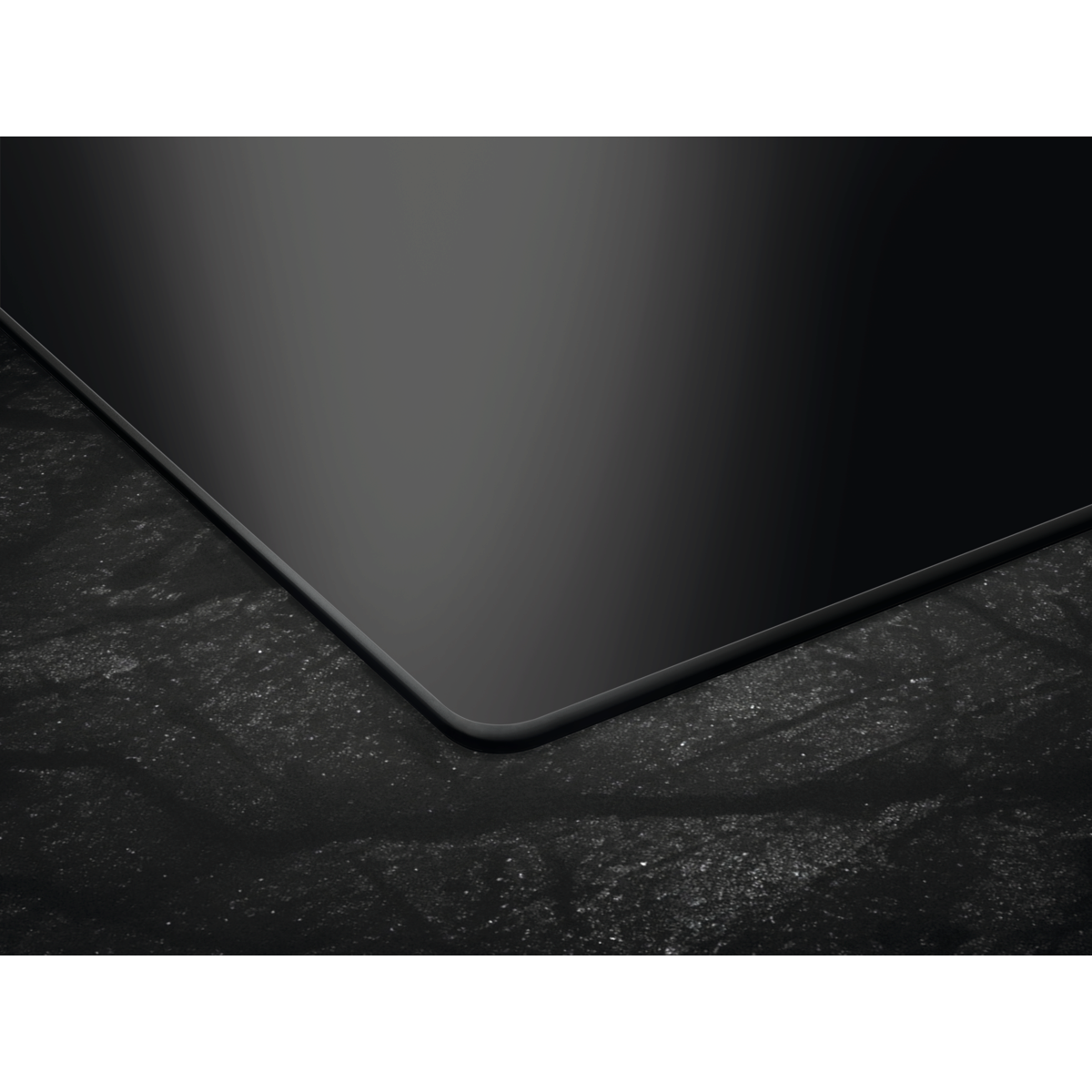 Vitrocerámica de inducción negra con superficie oscura y texturizada. Diseño minimalista.