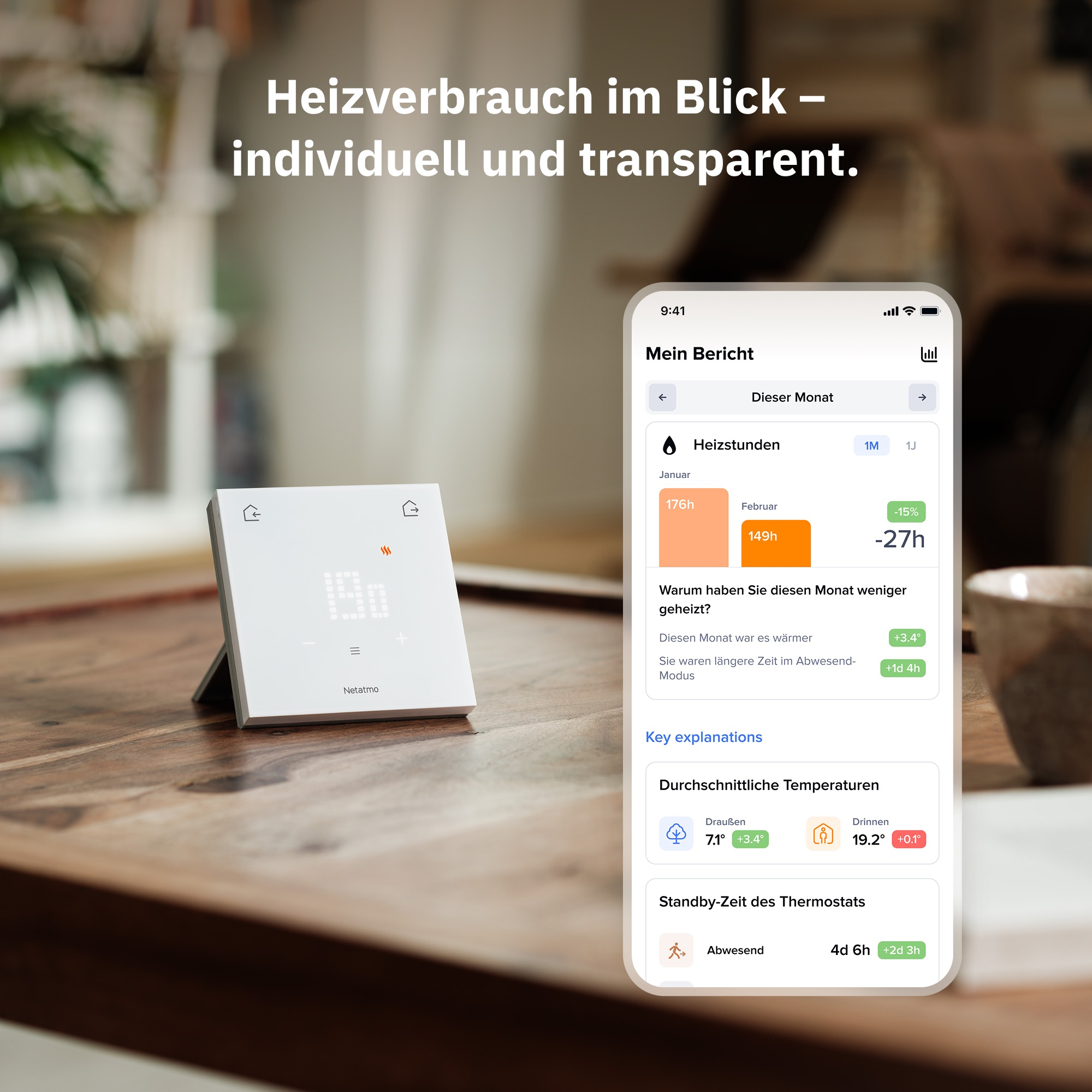 A white thermostat next to a smartphone displaying heating data.