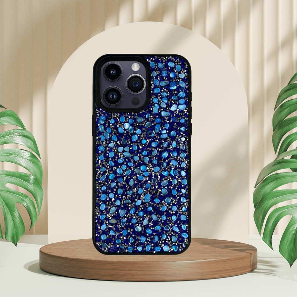 Yuvarlak bir podyum üzerinde taş mozaik desenli mavi telefon kılıfı.