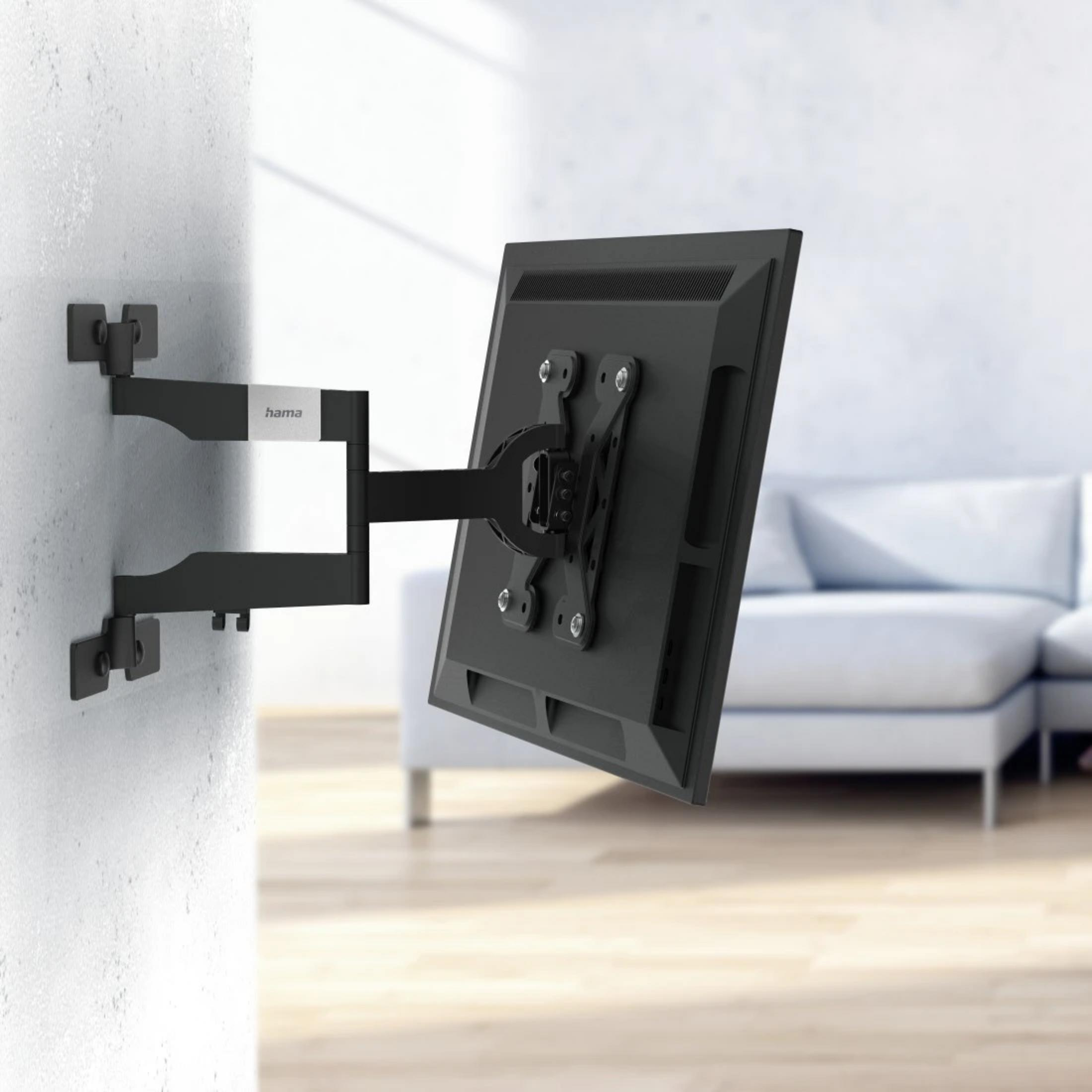 Ein schwarzer Fernseher an einer Wandhalterung im Wohnzimmer.