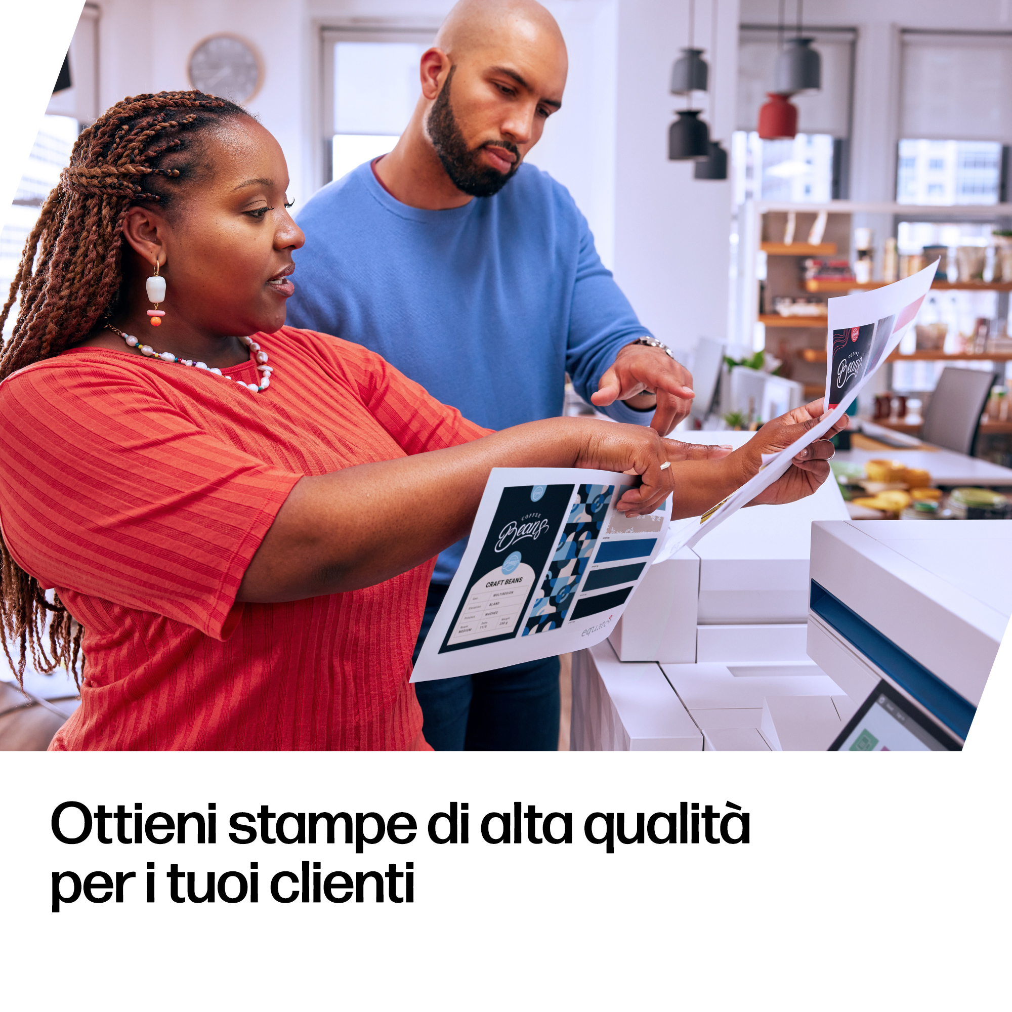 Two people review prints with coffee bean design next to a printer.