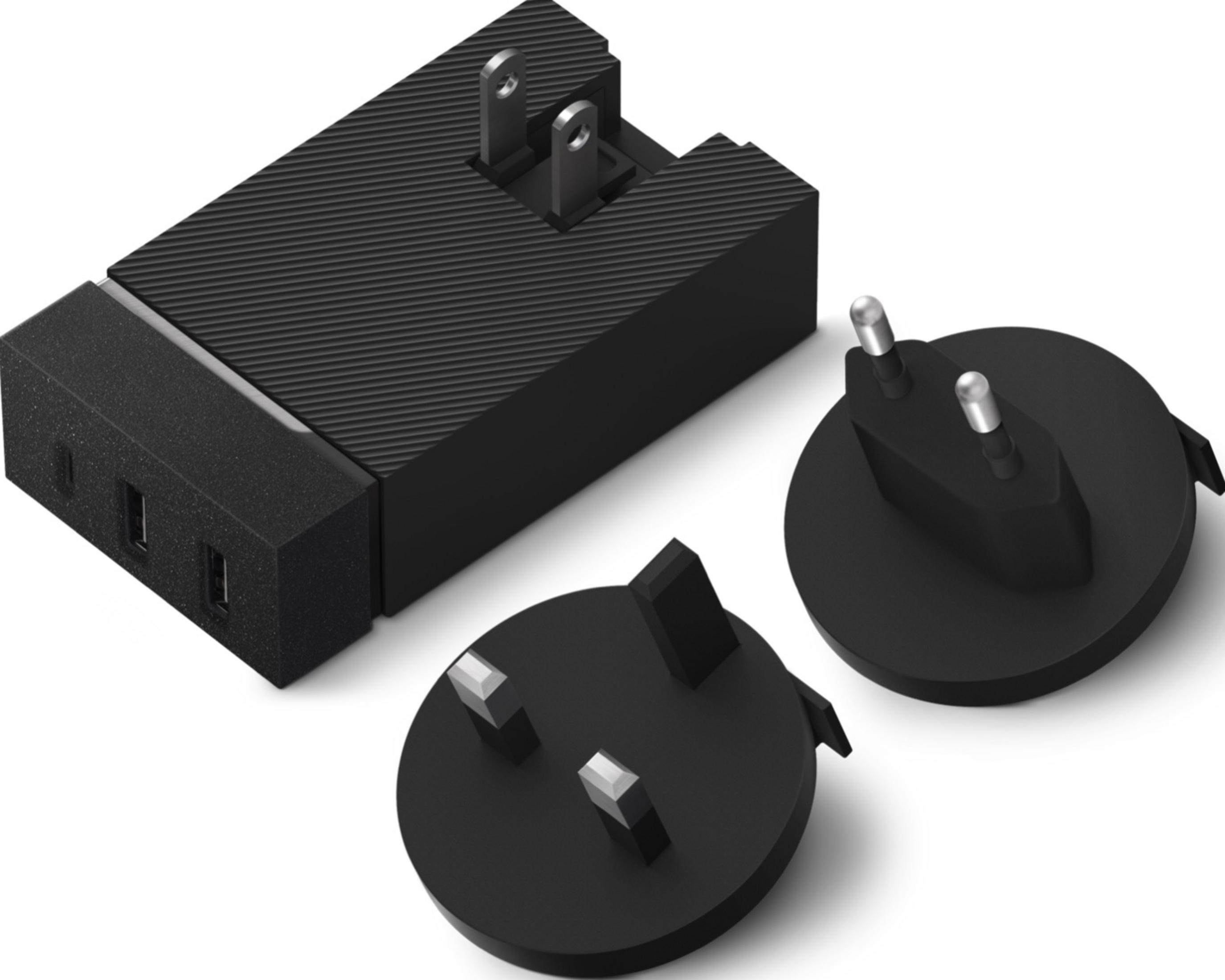 Adattatore da viaggio nero con spine intercambiabili e due porte USB.
