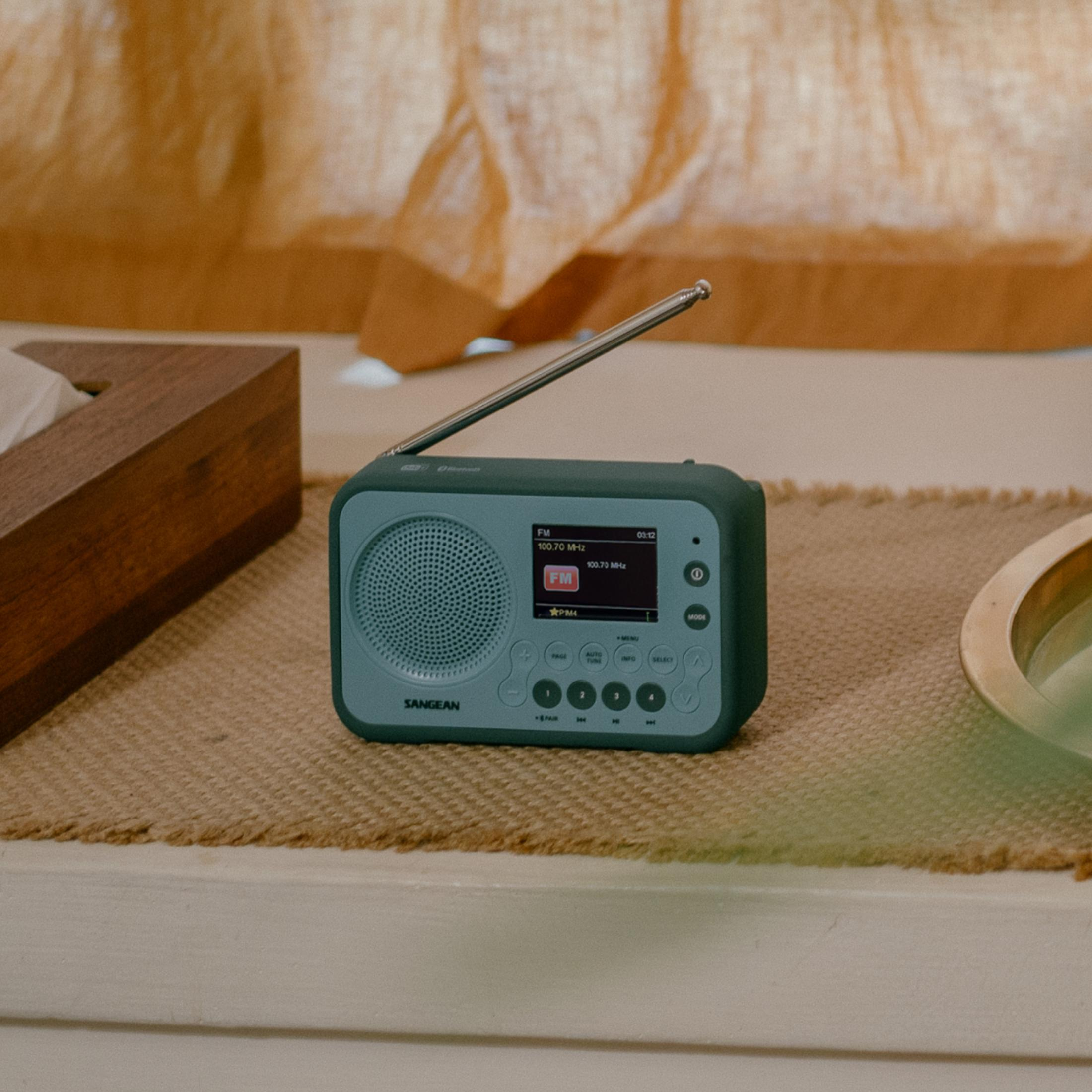 Une petite radio bleue avec une antenne est posée sur une surface texturée marron.