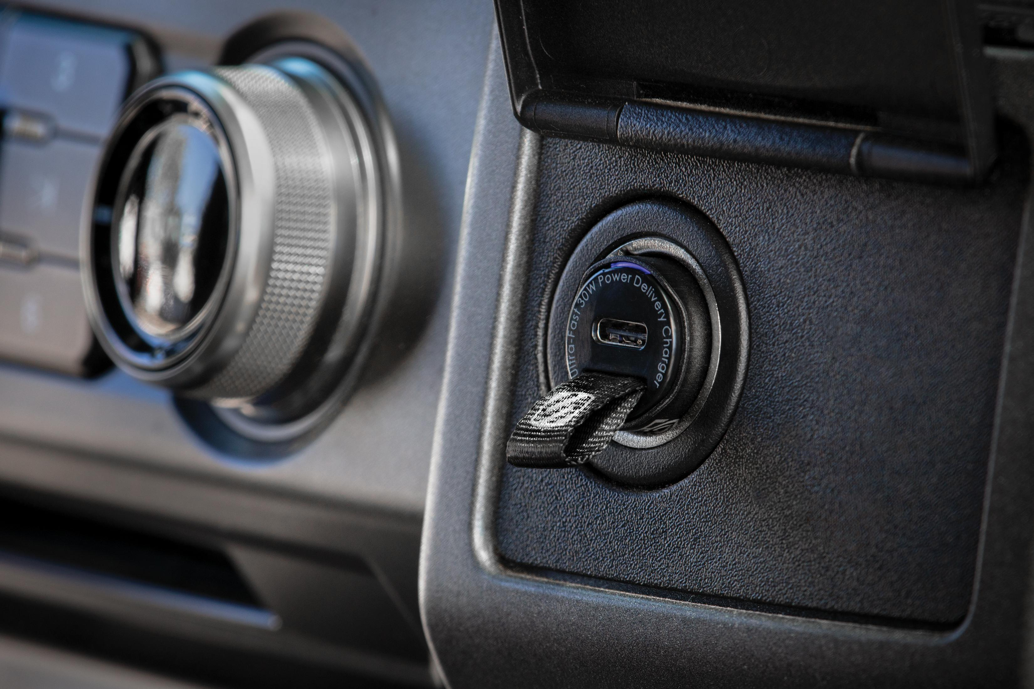 Ein USB-C-Ladegerät mit einer Zuglasche in einem Auto.