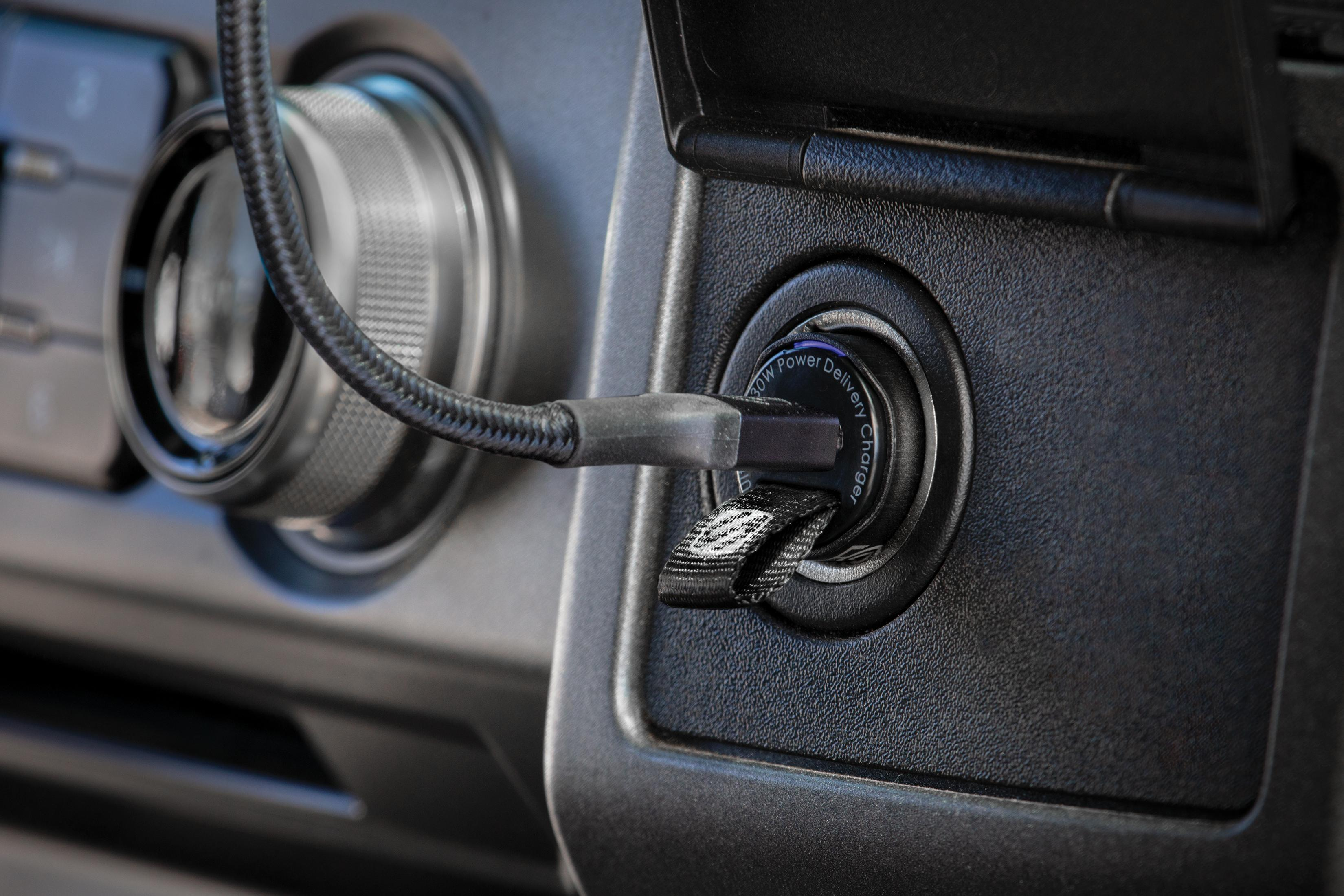 Ein schwarzes USB-C-Ladegerät mit 30W ist in eine Autosteckdose eingesteckt.