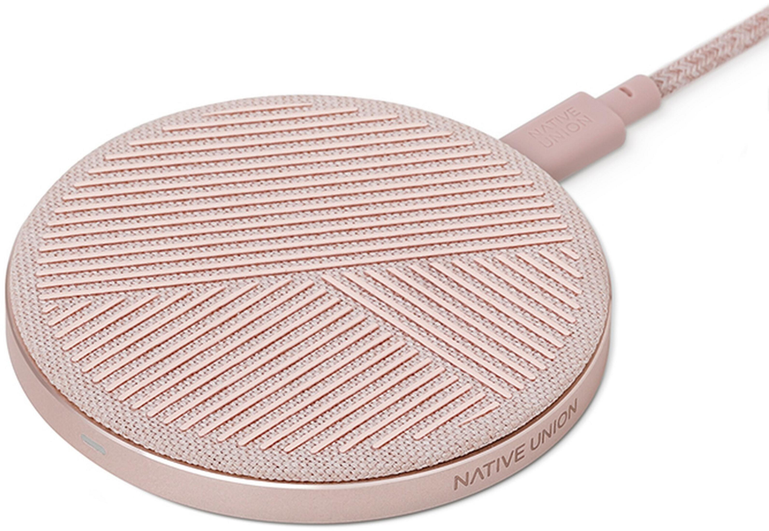 Un chargeur sans fil rond rose doré avec surface en tissu et câble.