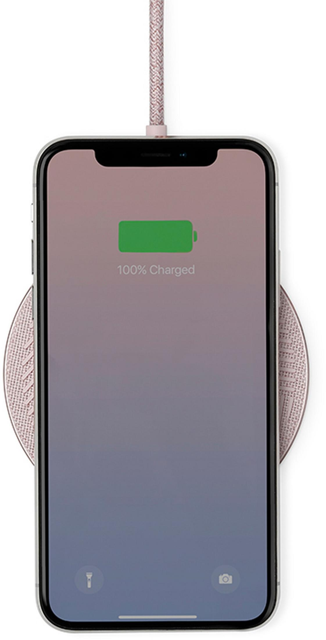 Un smartphone rose avec batterie à 100% sur un chargeur sans fil.