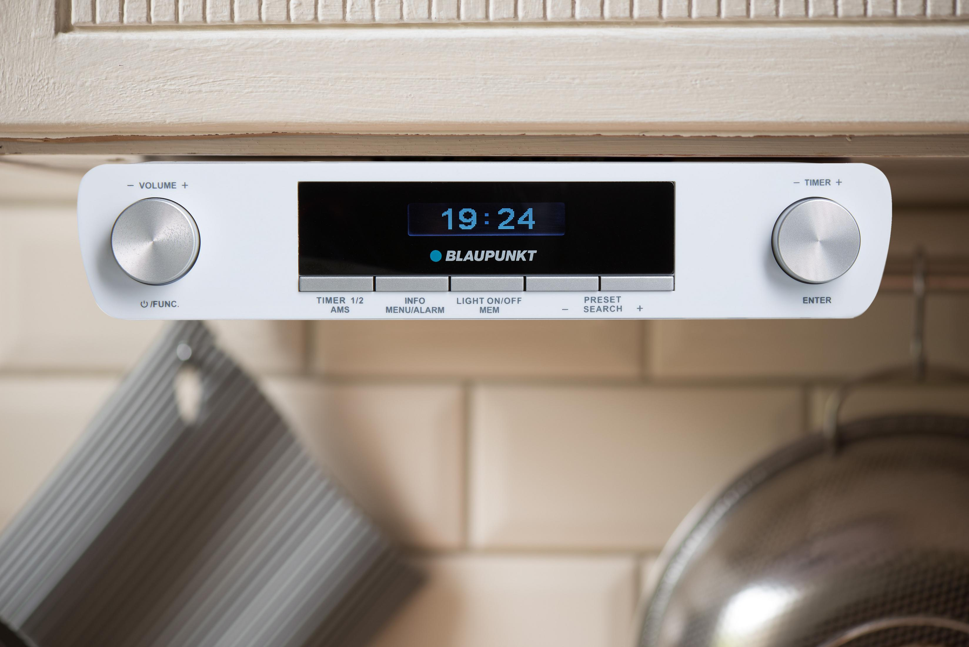 Ein weißes Blaupunkt-Radio unter einem Küchenschrank mit silbernen Knöpfen und digitaler Zeitanzeige.