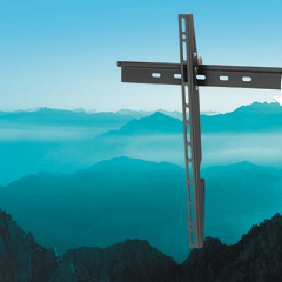 Ein schwarzer Fernsehhalter steht vor einer Berglandschaft im Morgennebel.