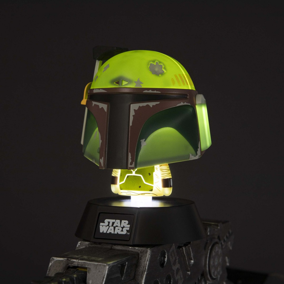 Lampa hełm Boba Fett świeci na zielono na czarnej podstawie z logo Star Wars.