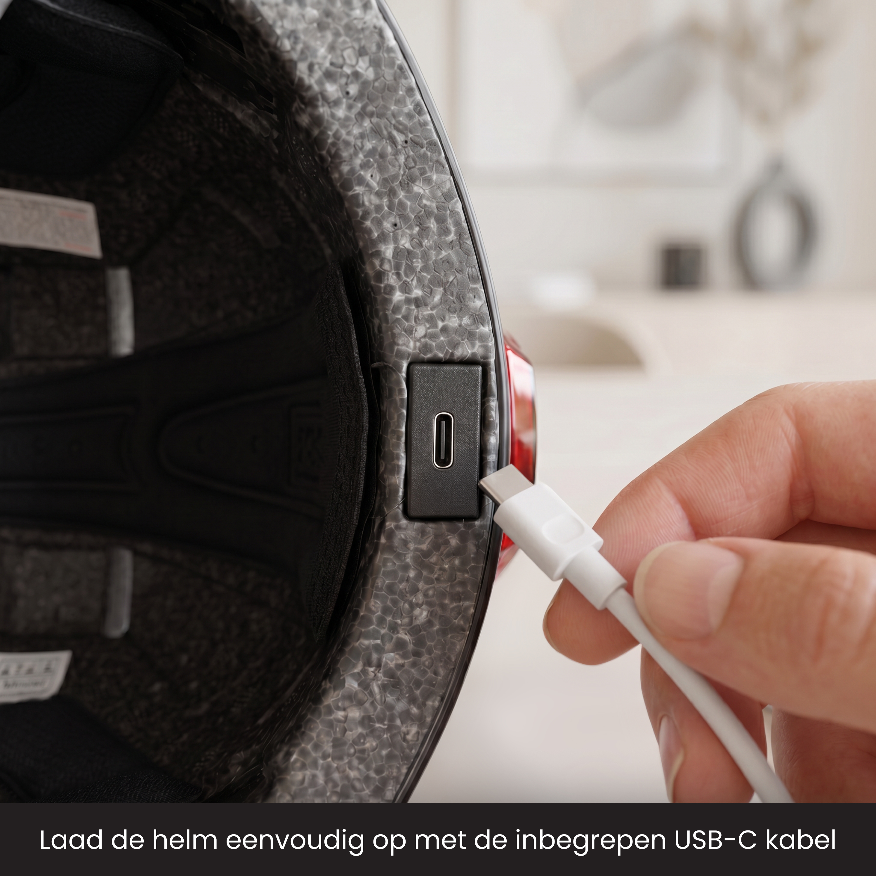 Ein weißes USB-C-Kabel wird in einen schwarzen Helm gesteckt.