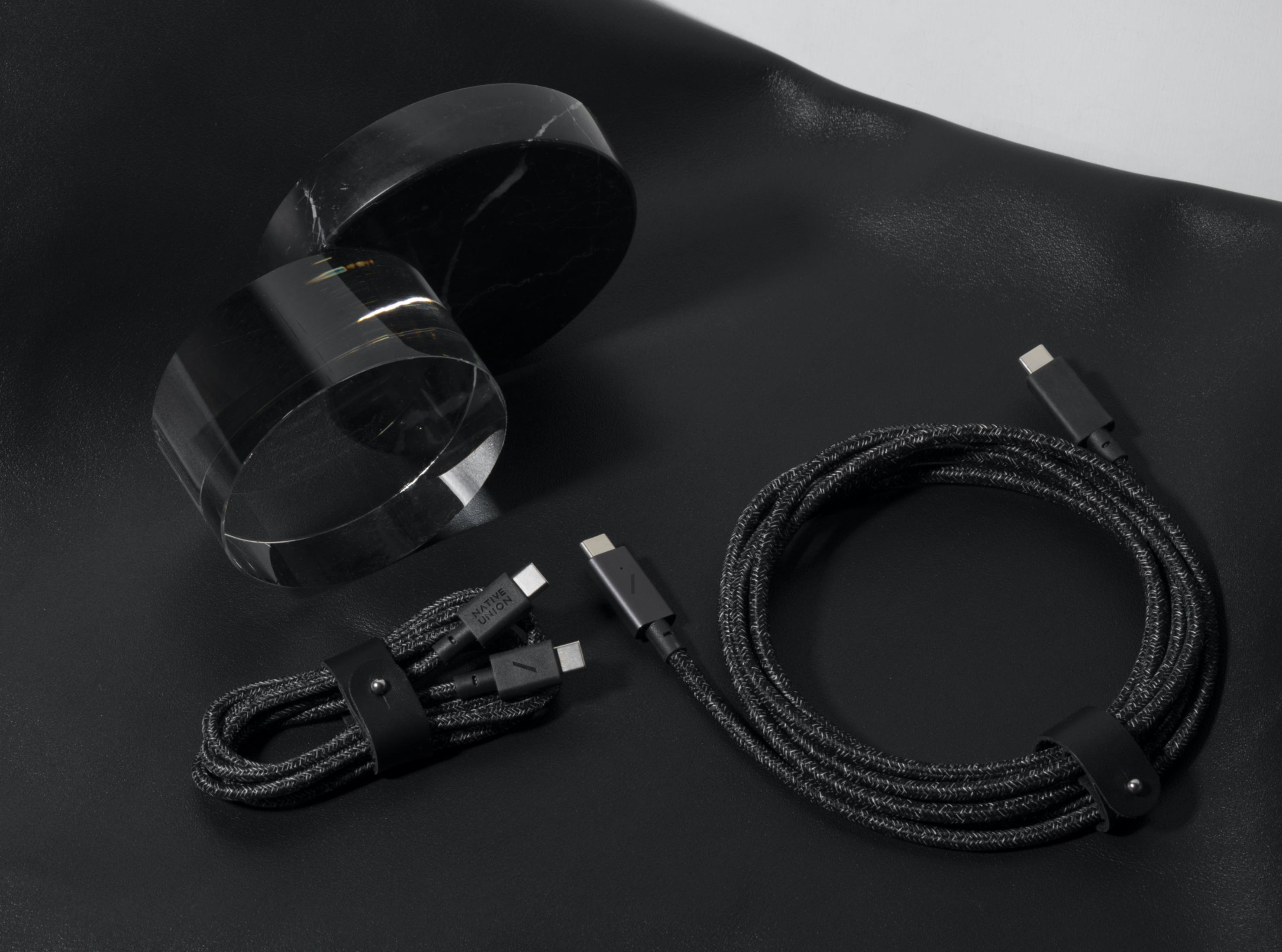Due cavi neri con connettori USB-C giacciono su una superficie nera.