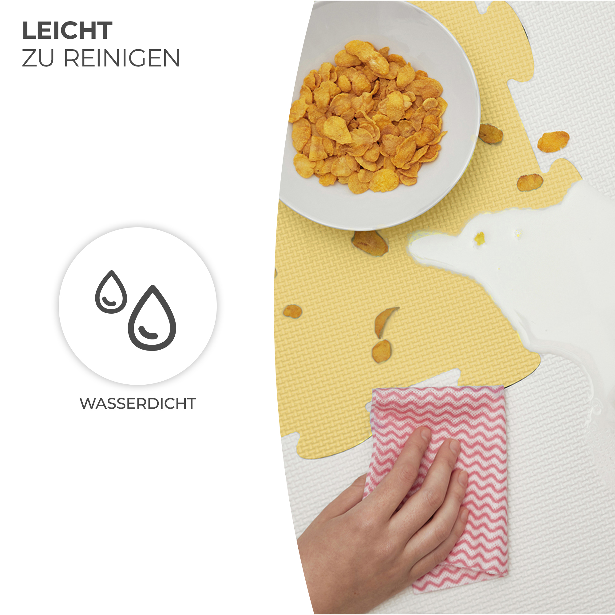 Eine Hand wischt verschüttete Milch mit einem rosa-weißen Tuch weg.