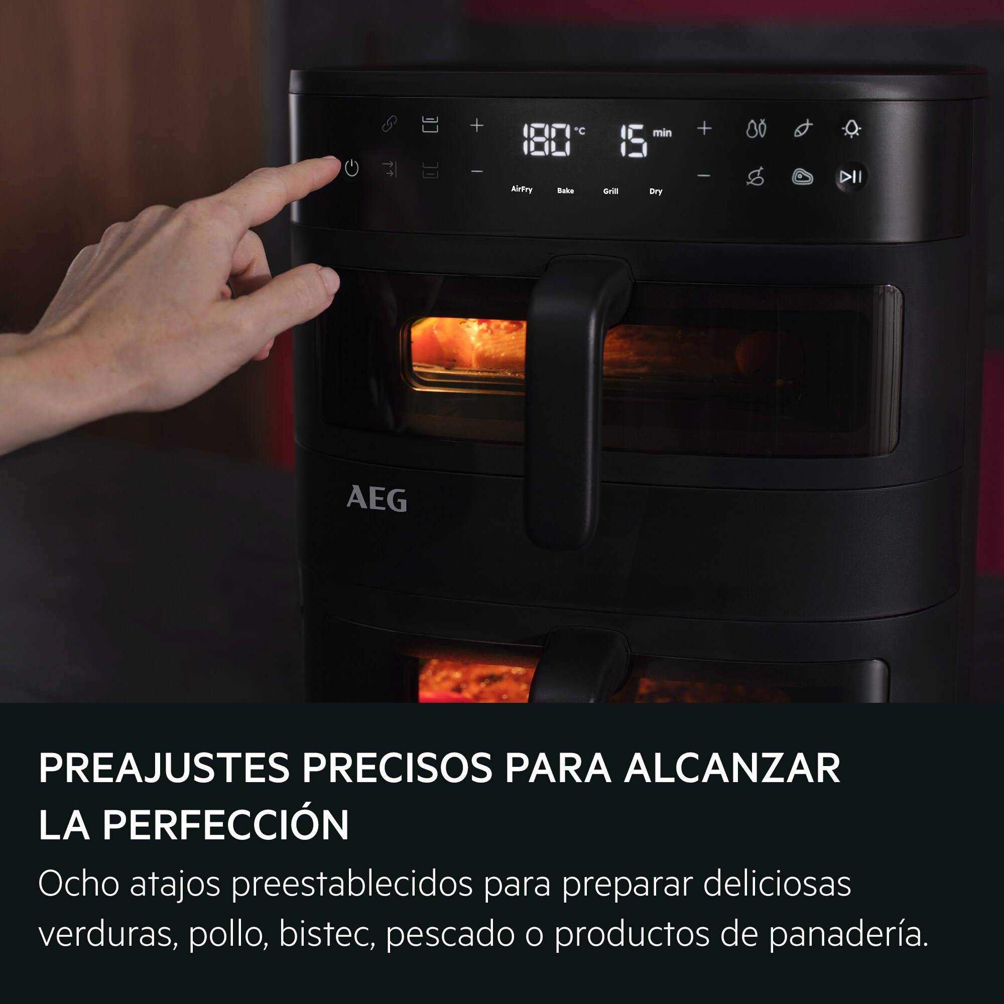 Una mano presiona un botón en el panel de control de una freidora de aire AEG.