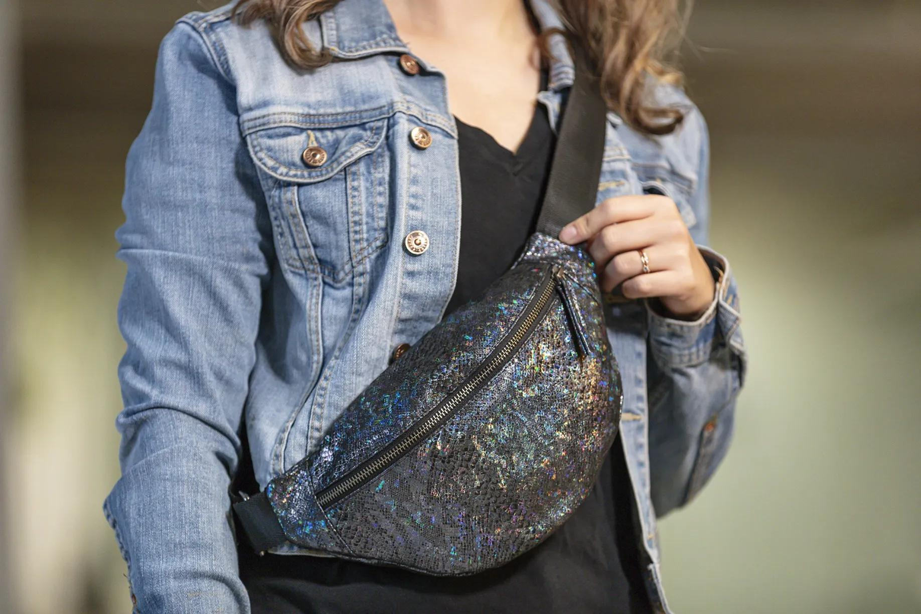 Mujer con riñonera brillante y chaqueta vaquera.