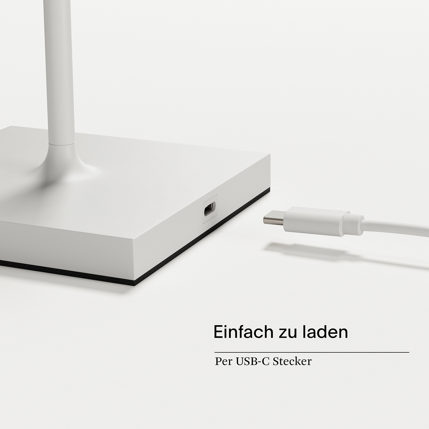 Ein weißes Ladekabel wird in eine weiße Basis gesteckt.