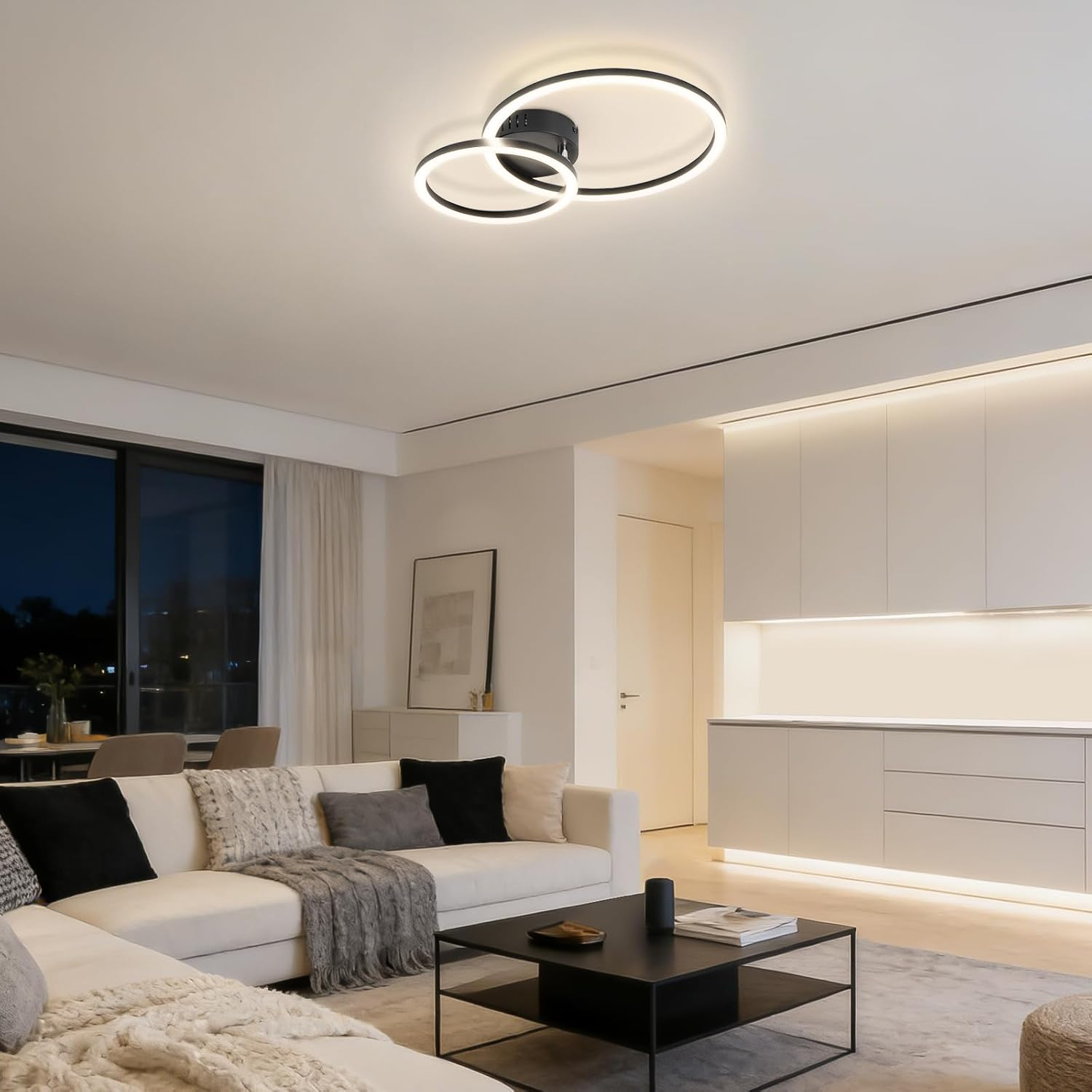 Modernes Wohnzimmer mit weißem Sofa, schwarzem Couchtisch und Deckenleuchte.