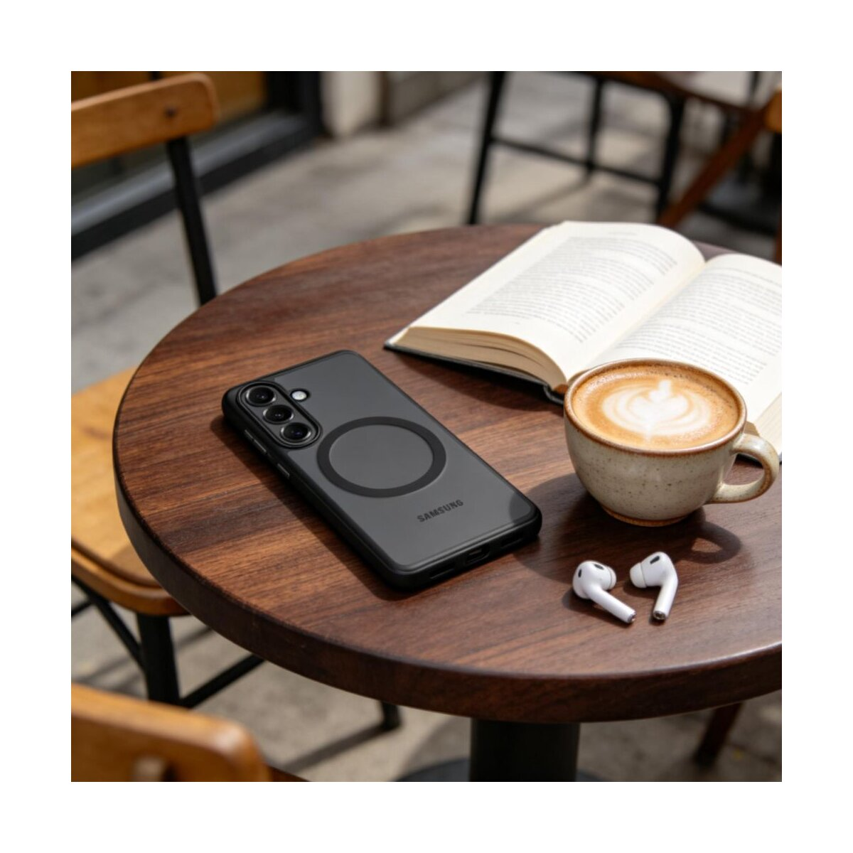 Ein Handy, ein Buch und Kaffee auf einem Holztisch im Freien.