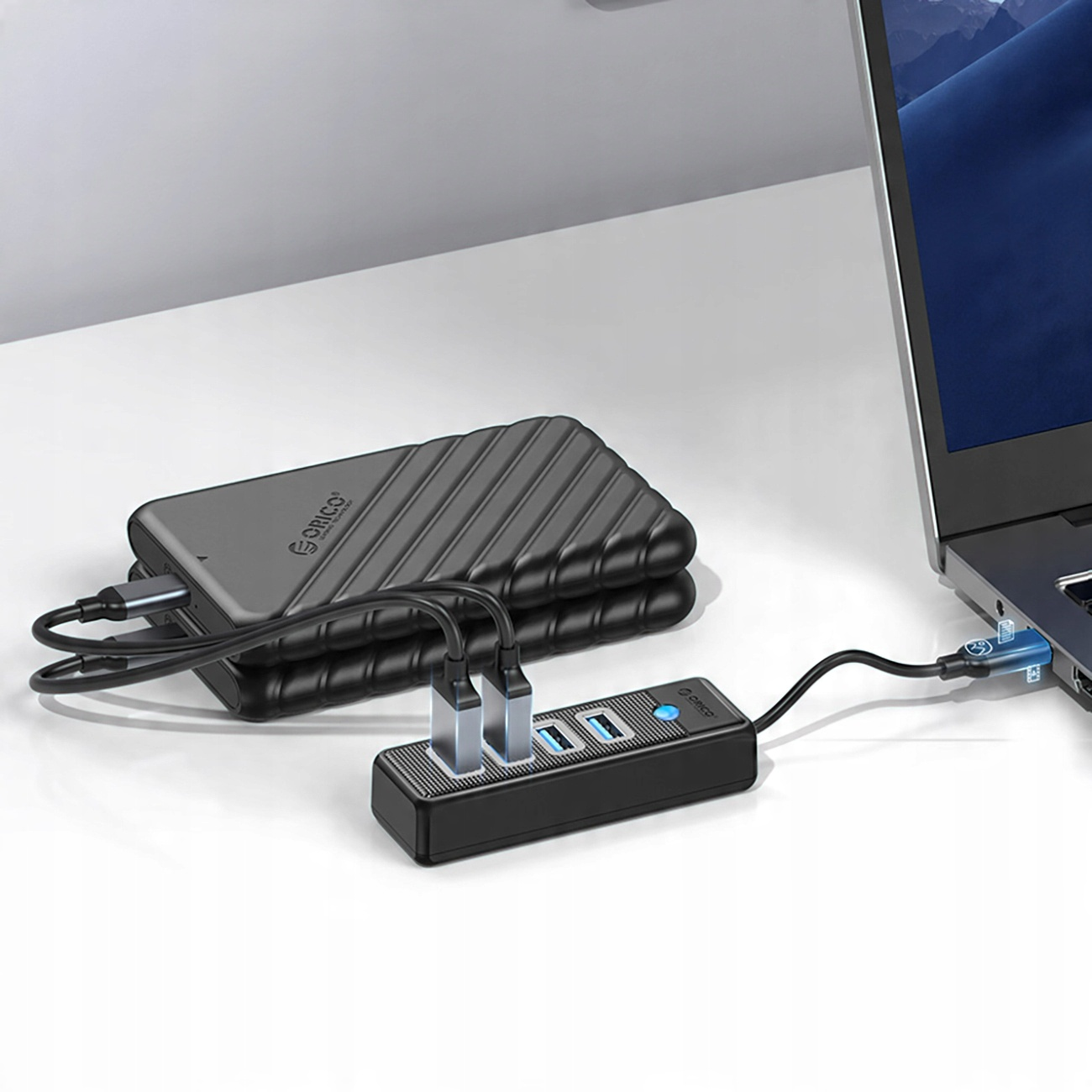 Hub USB nero a quattro porte collegato a un hard disk esterno e a un laptop.