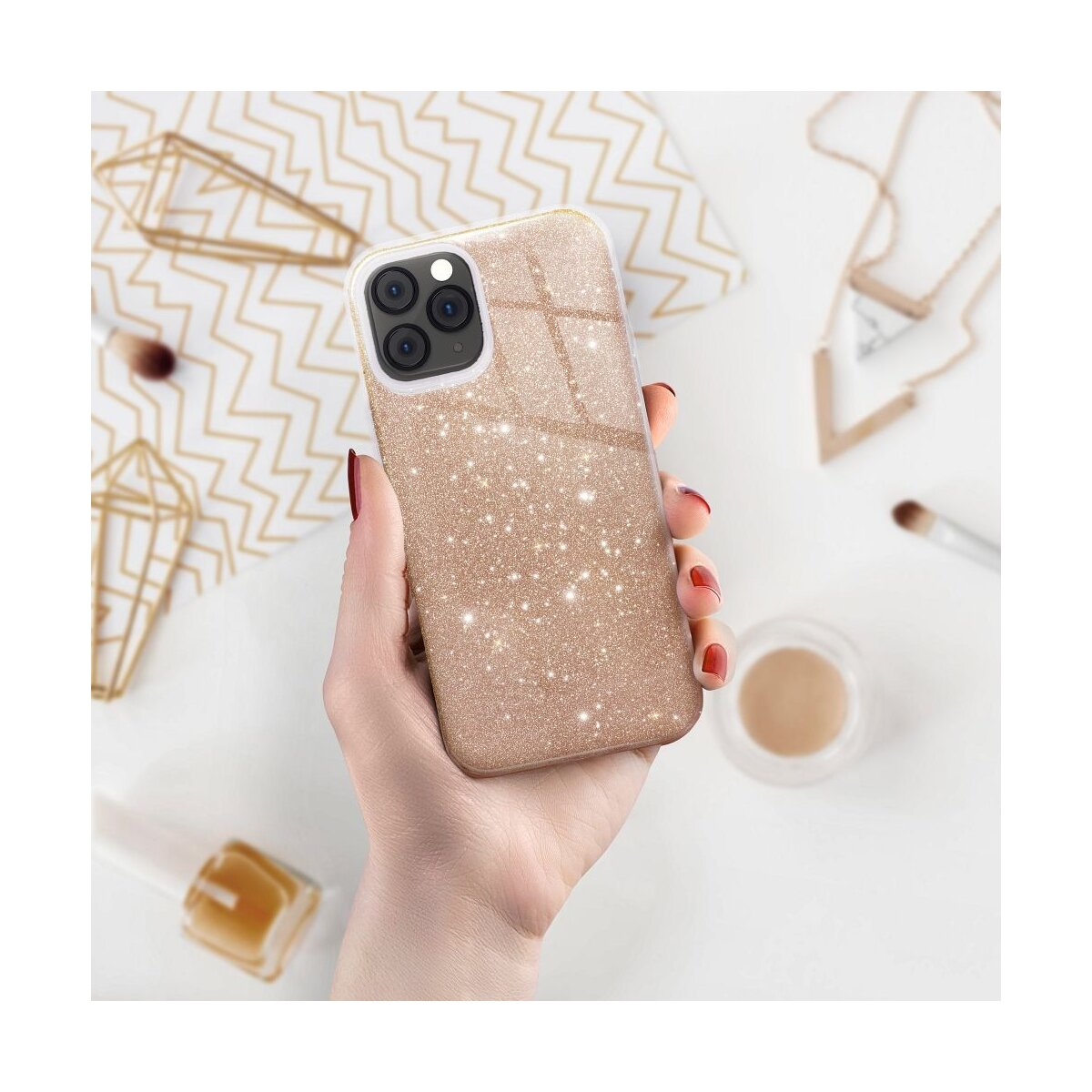 Eine Hand hält ein glitzerndes Handyhülle in Roségold. Dekorationen im Hintergrund.