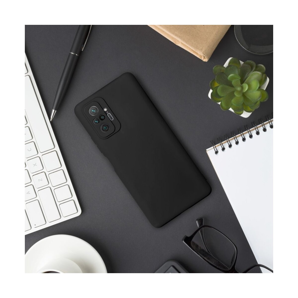 Schwarzes Smartphone mit Kameras, Tastatur, Stift, Brille und Pflanze.