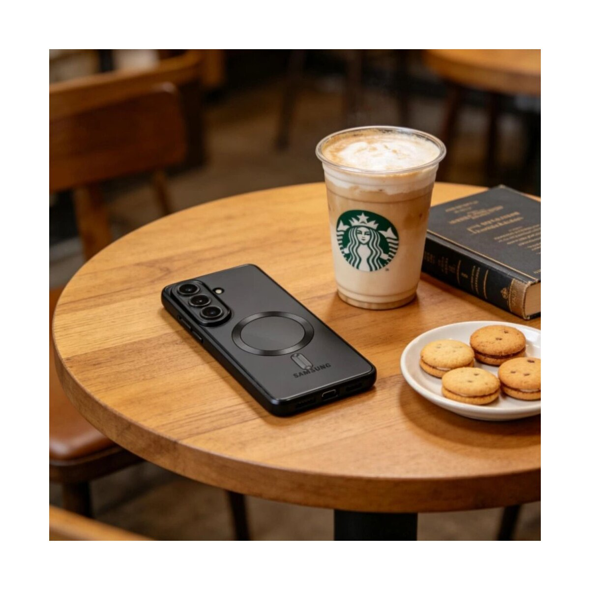 Schwarzes Smartphone mit Ladekreis, Kaffee und Keksen auf Holztisch.