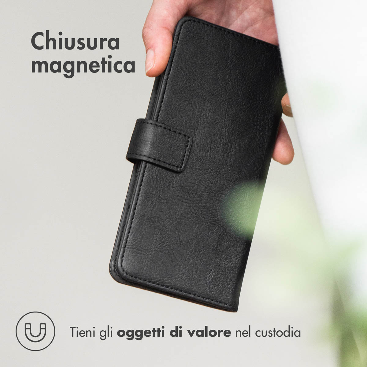 Zwarte lederen hoes met magnetische sluiting, in de hand gehouden.